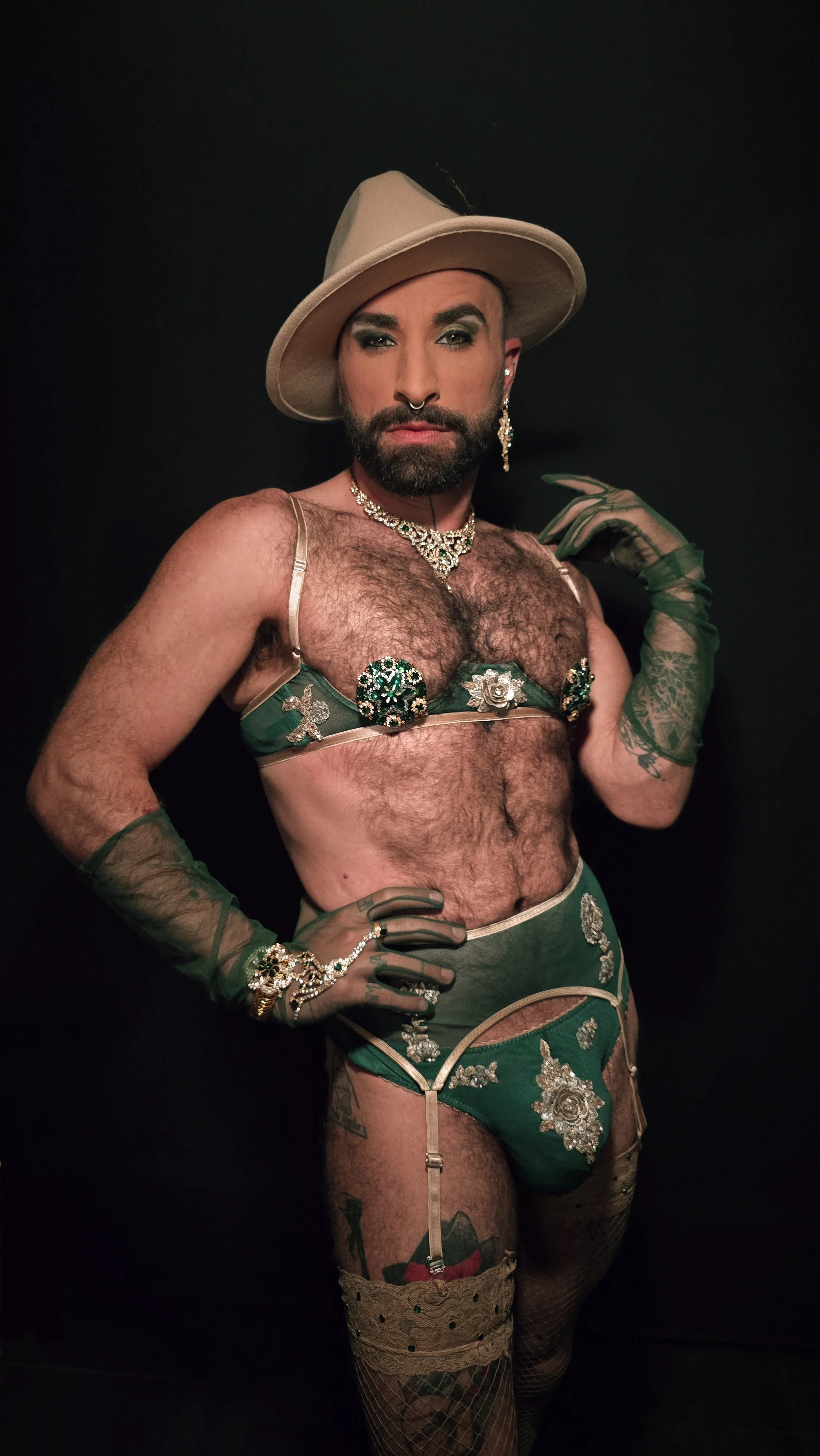 Femme Fatale male in green lingerie and a fierce gaze