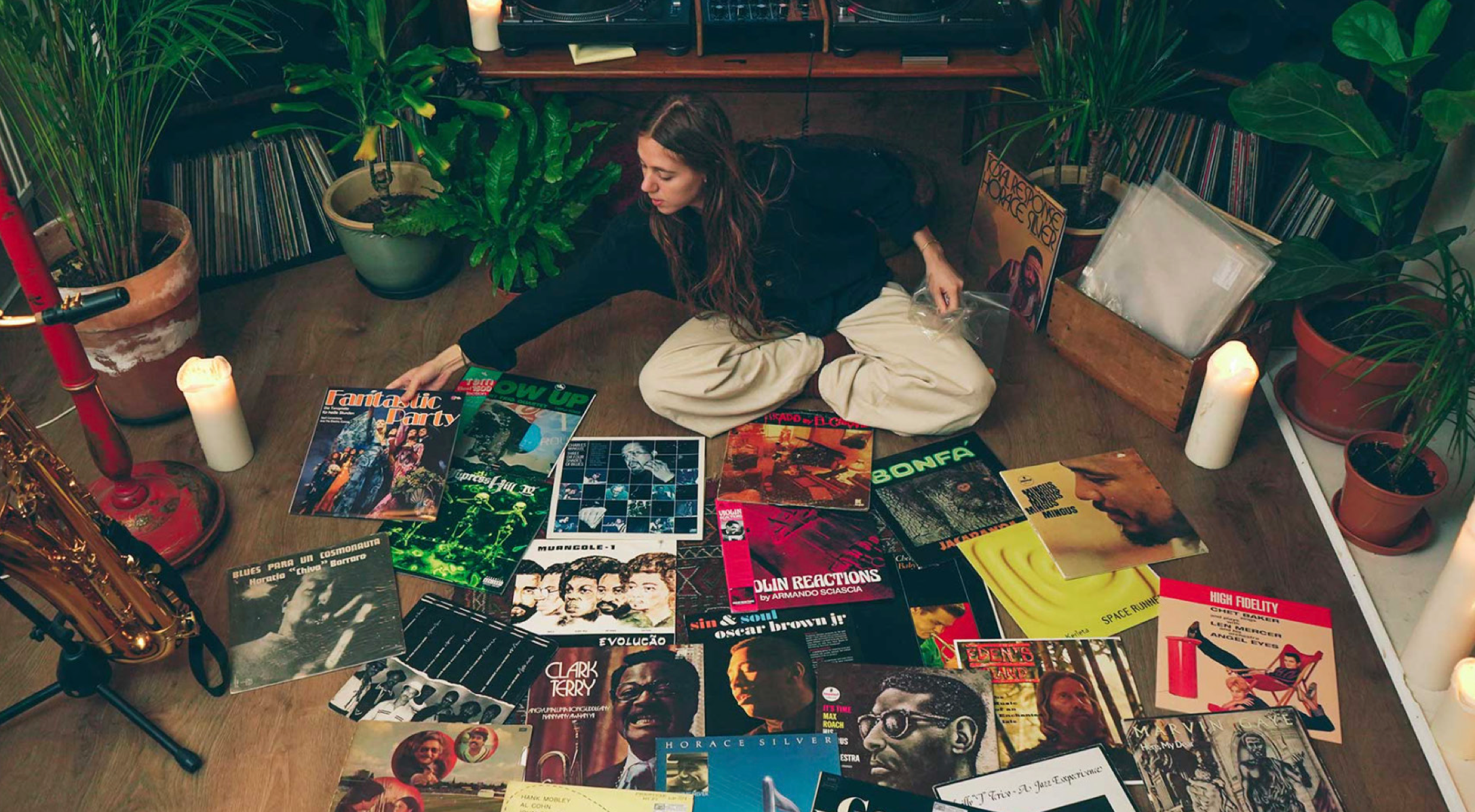 Girl places vinyl records on the wooden  floor