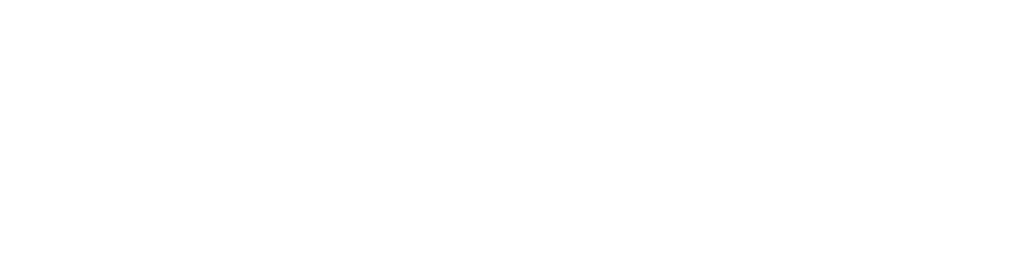 A person in black tee shirt and pants sculpting clay on a work table in an art studio.