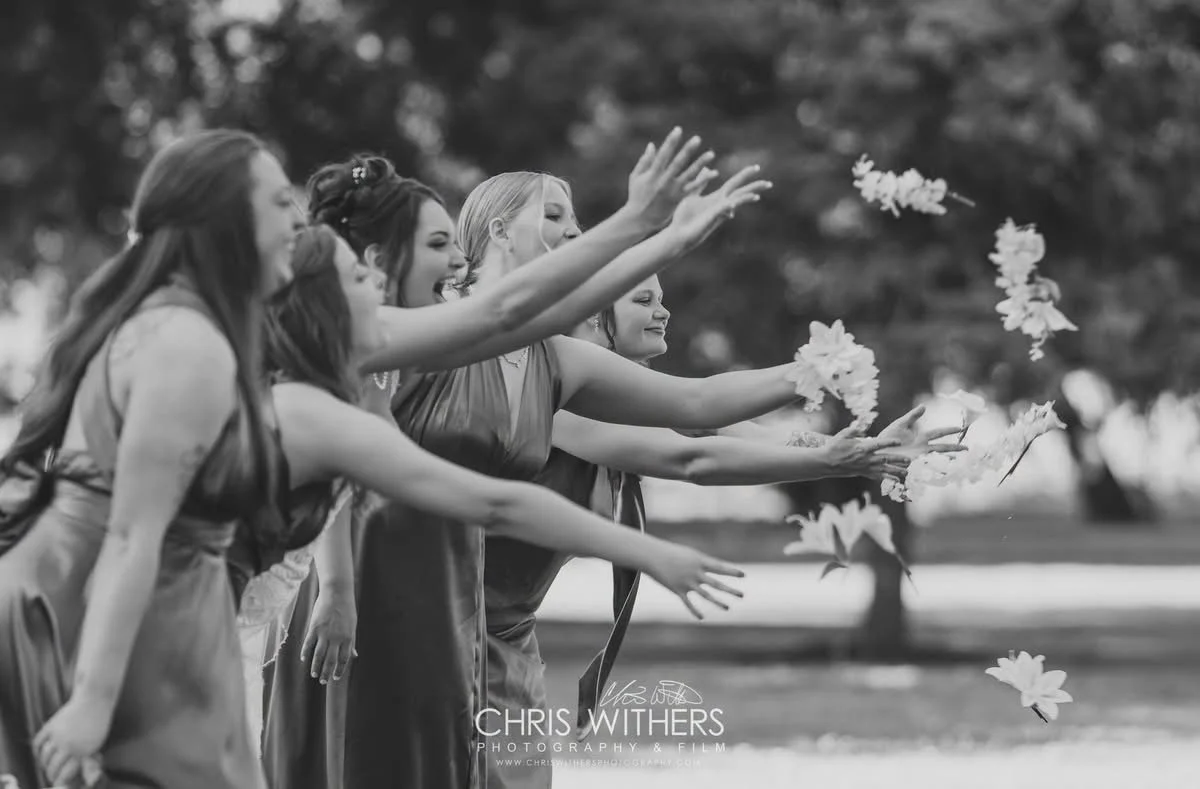 Women throwing flower petals in the air outdoors