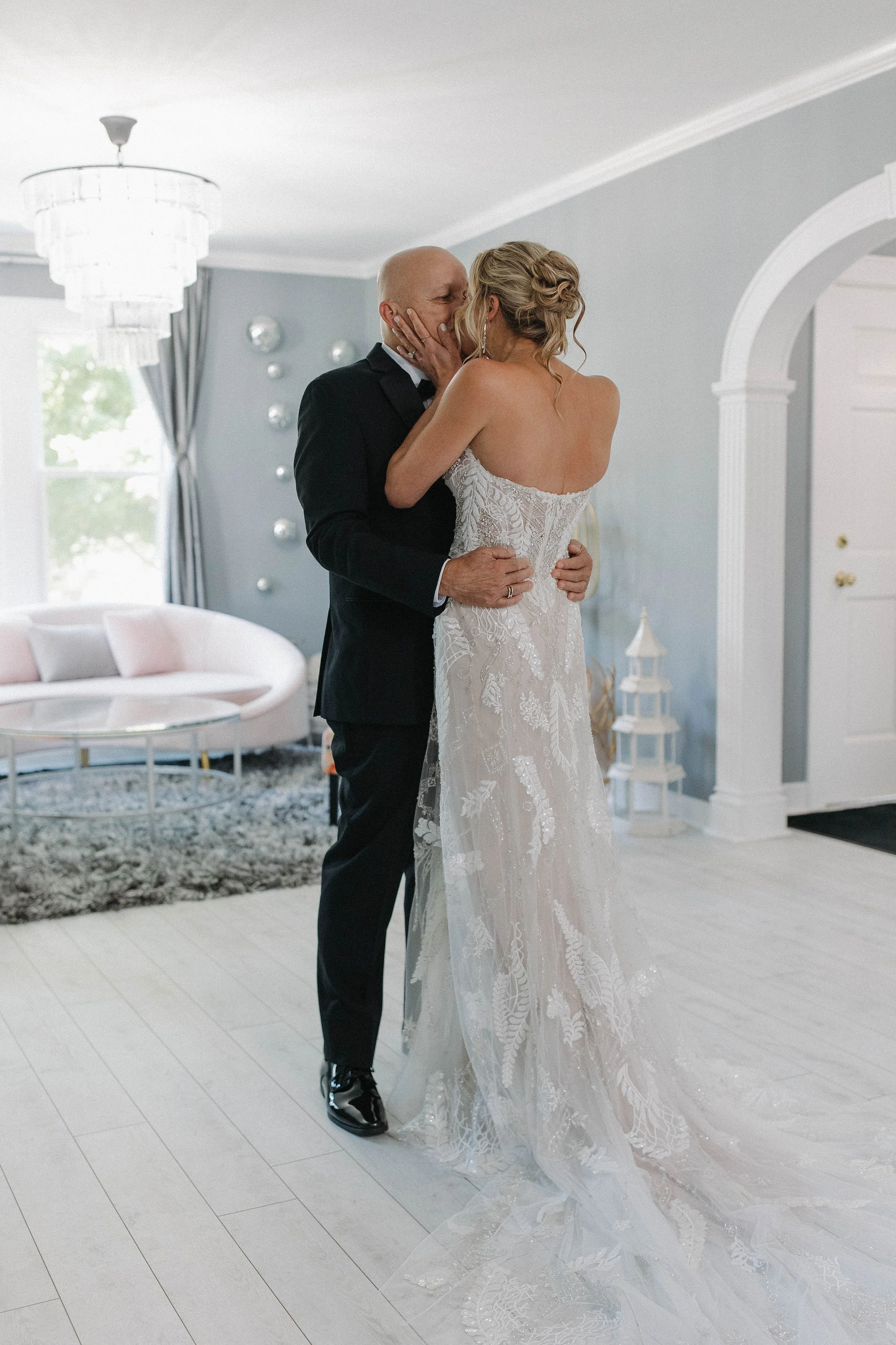 A bride and groom sharing a kiss in a living room celebrating their wedding.