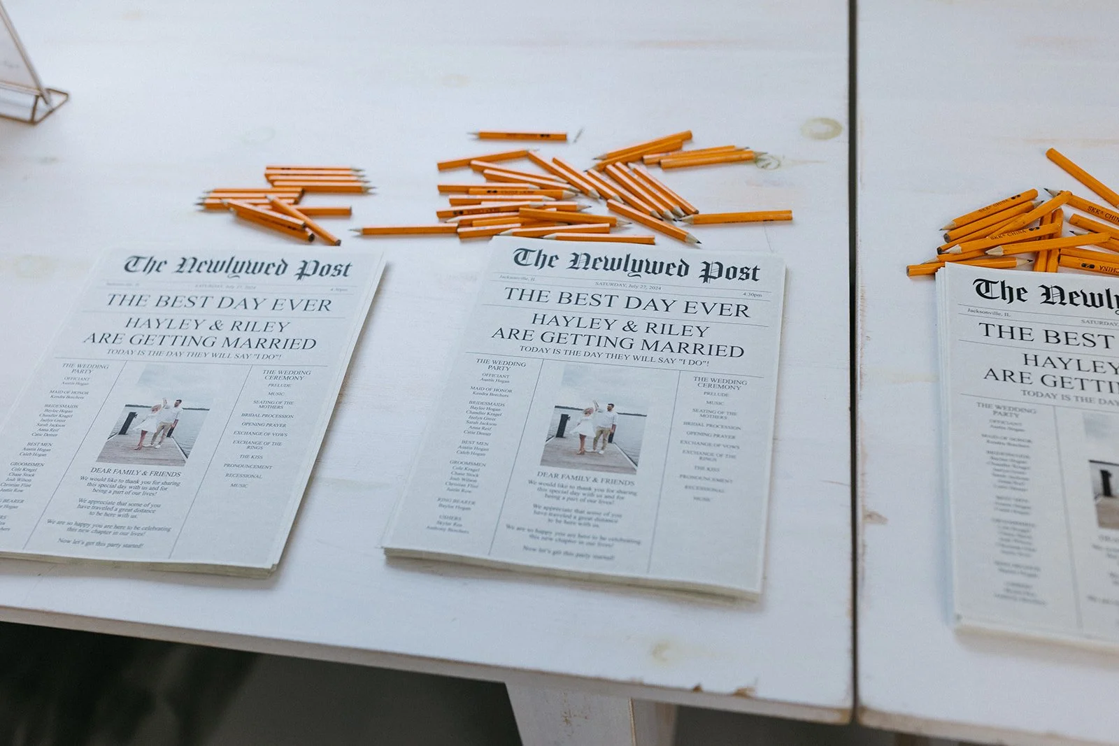 Wedding programs and yellow pencils arranged on a table for a wedding event.