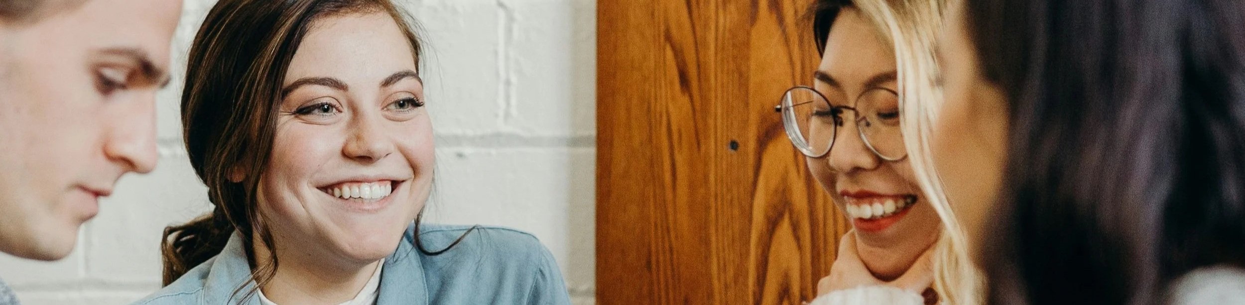 Four colleagues smile at each other during a meeting