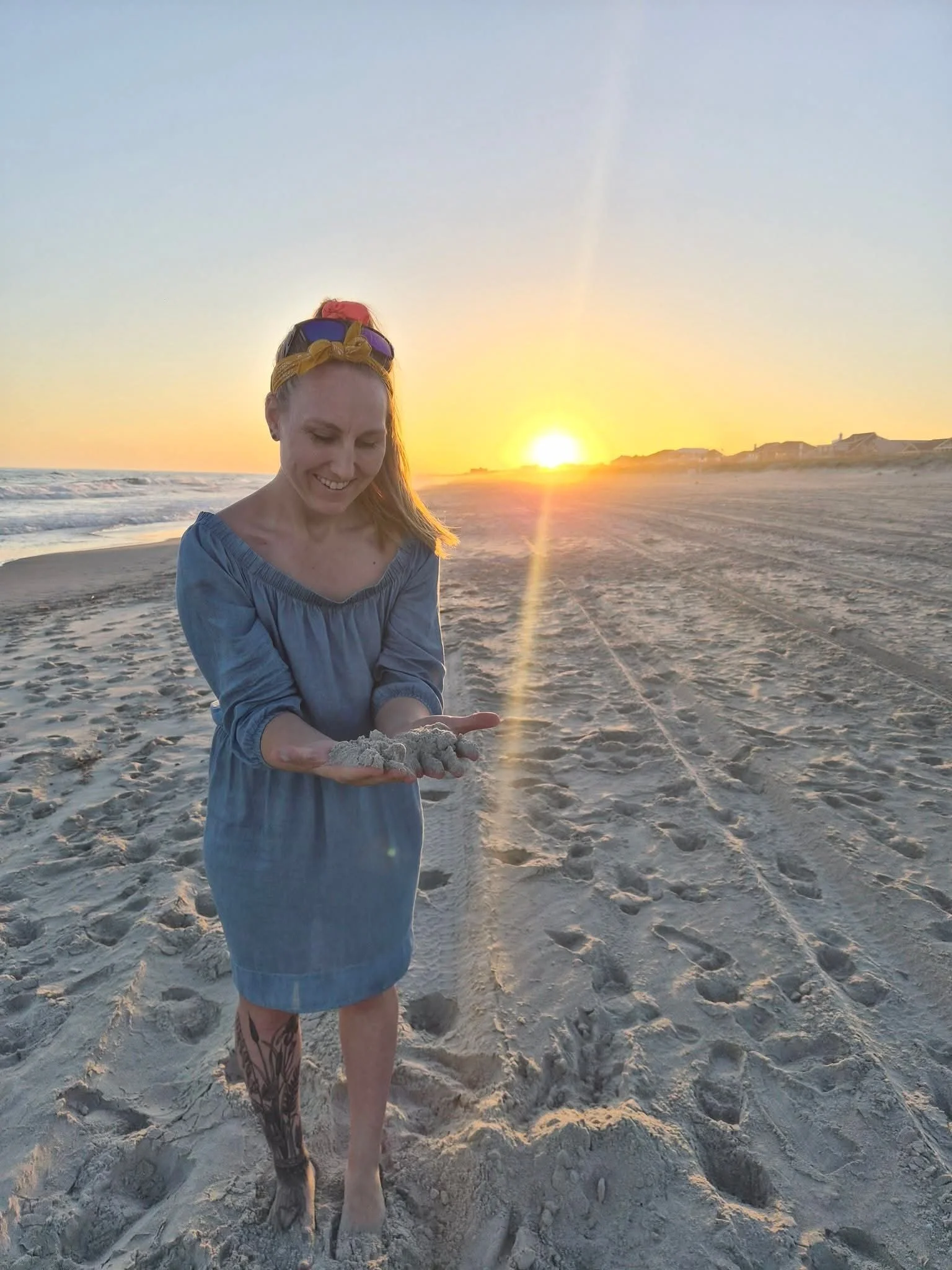 Blonde woman smiling while at the beach during sunset