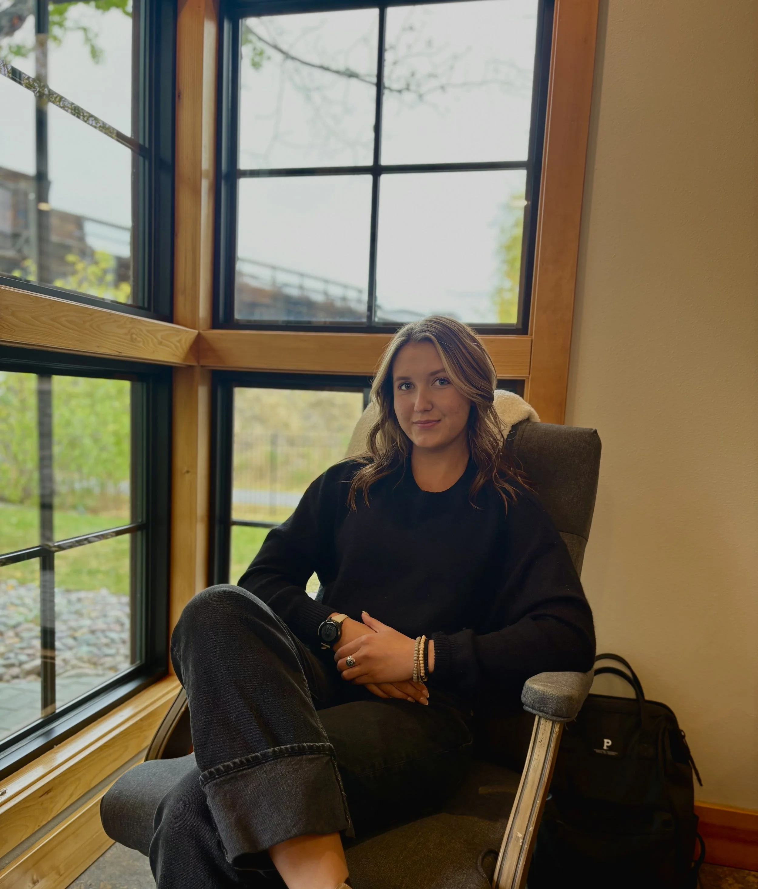 Professional portrait of a young woman sitting in a golden lit room