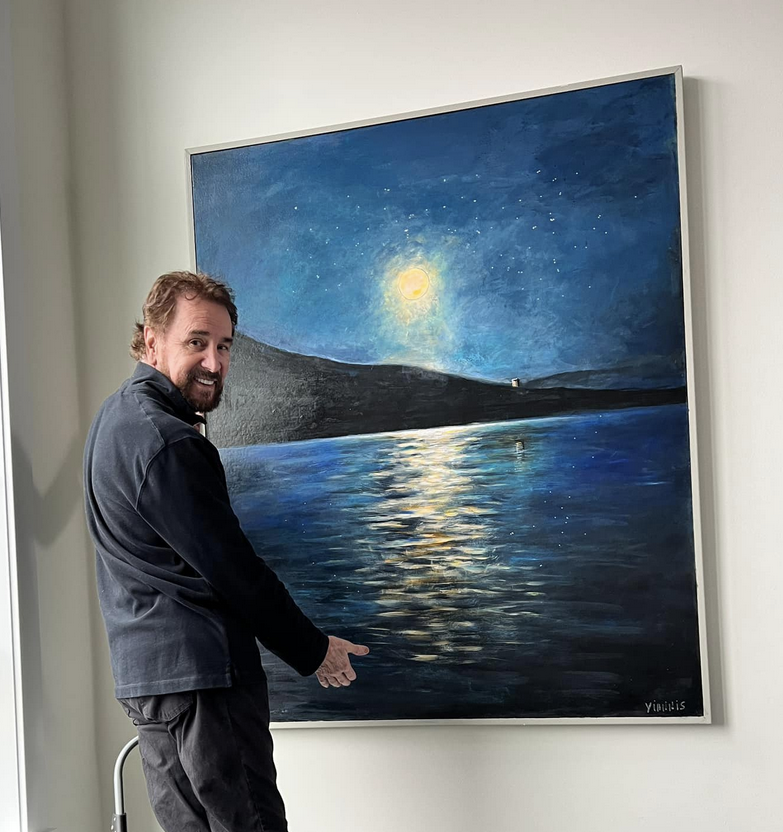 Person pointing at a painting of a night landscape with a bright moon and reflections on water.