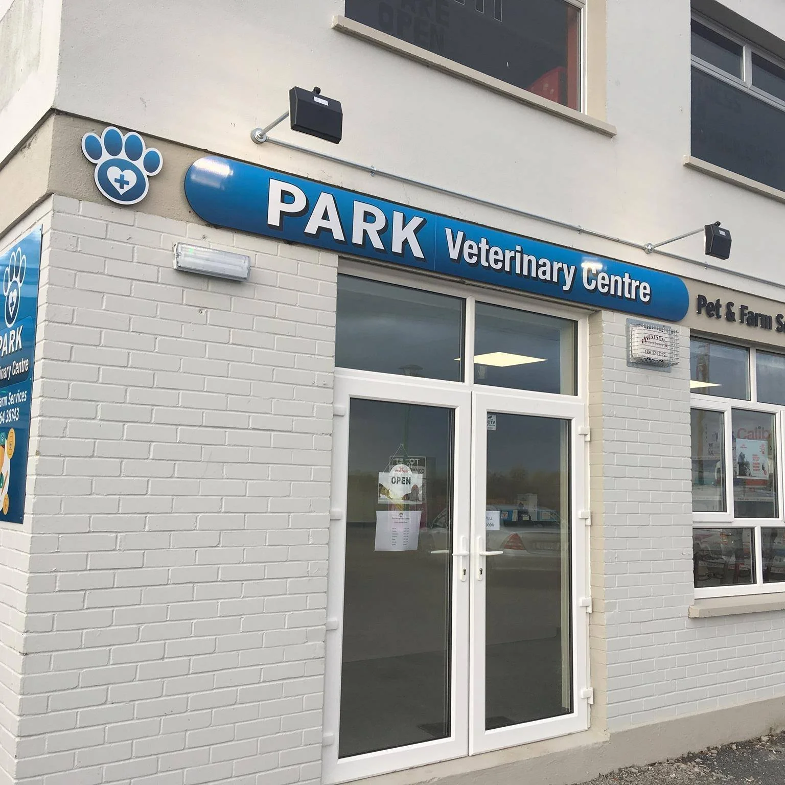 Exterior view of a pet and veterinary center with a blue sign that reads 'PARK Veterinary Centre' on a white brick building.