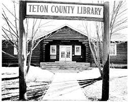 The Teton County Library building with a wooden facade and a covered entrance, surrounded by bare trees in winter.