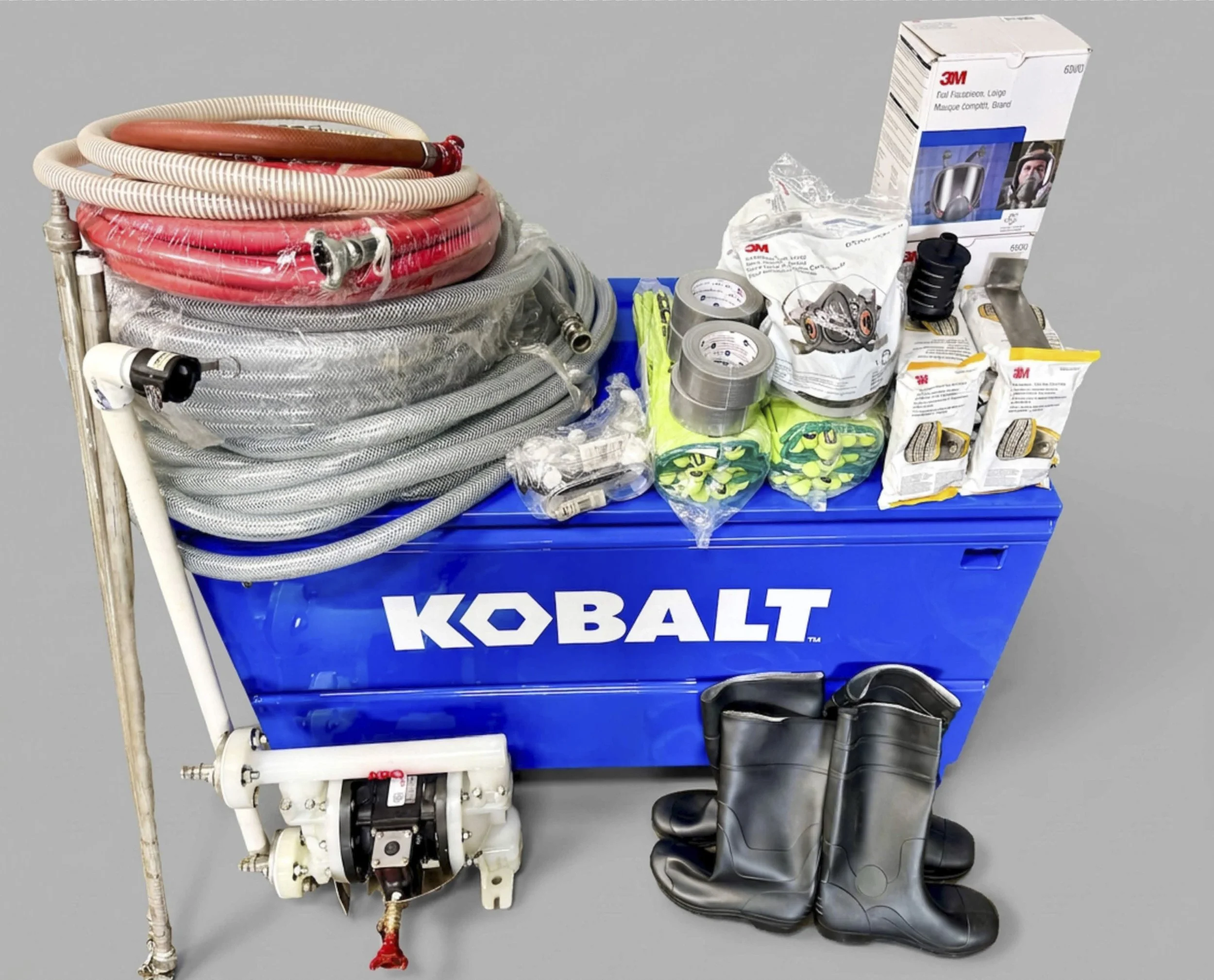 A blue Kobalt tool cart with various items including a portable water pump, vacuum hoses, tape rolls, gloves, and a box of 3M respirator filters. A foot and part of a black tool are visible at the bottom.