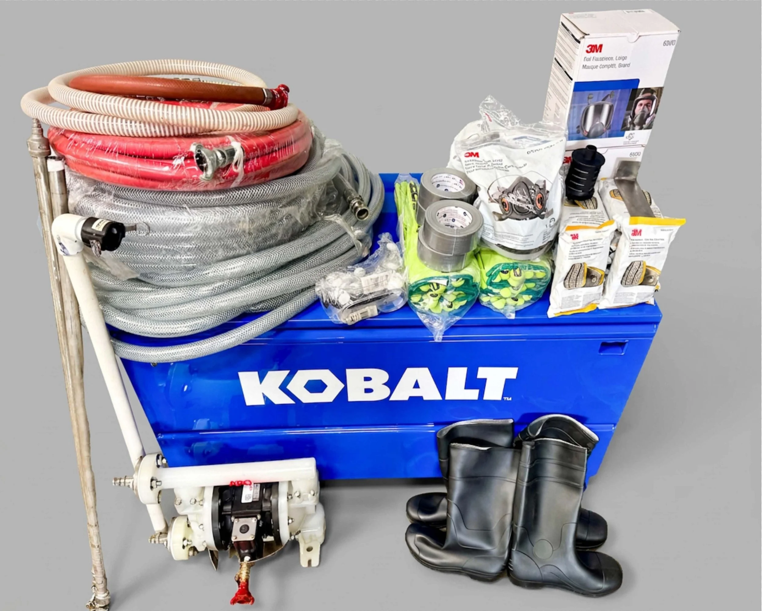 Kobalt toolbox with hoses, tools, and equipment, along with a pair of black rubber boots, set against a plain background.