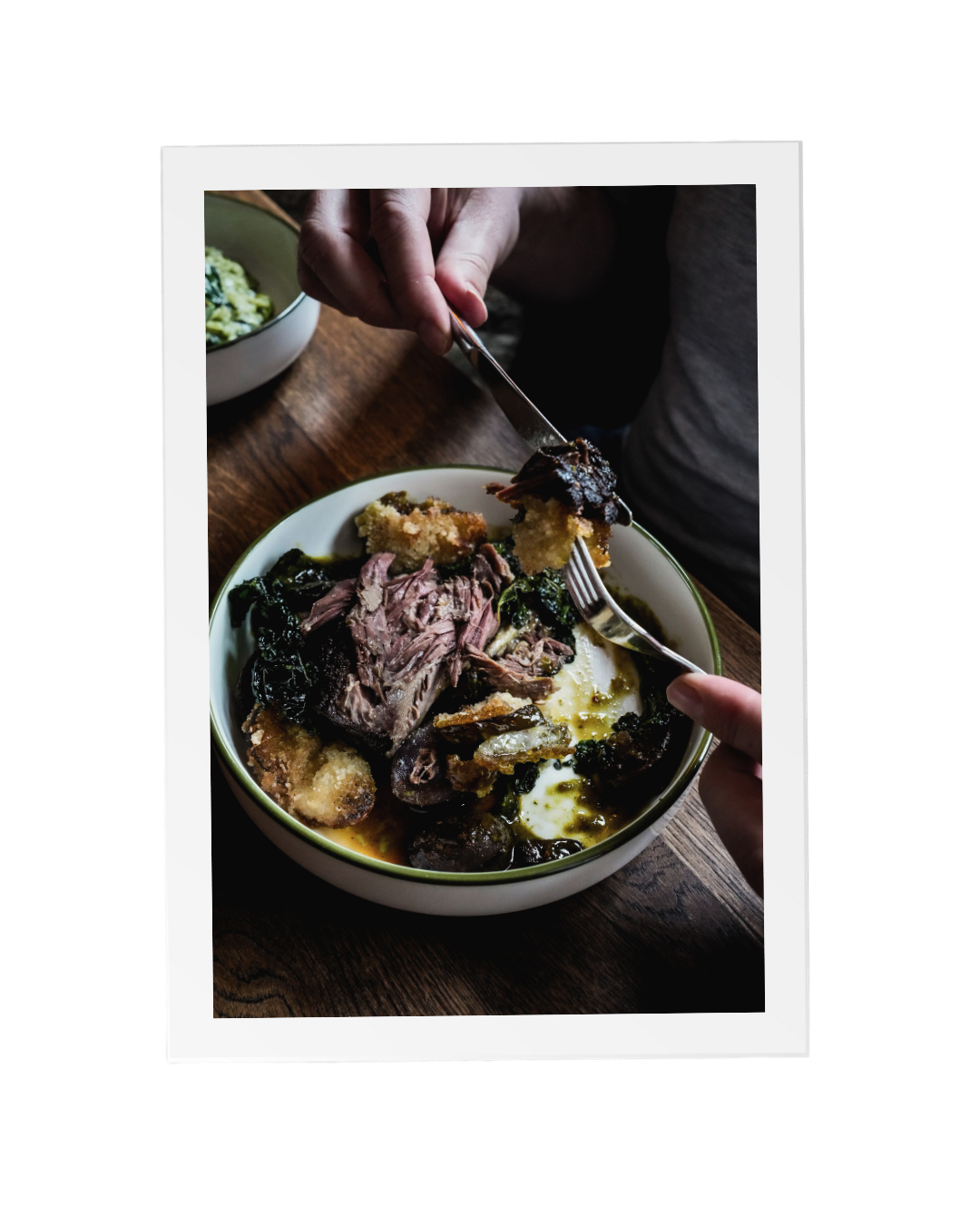An image of someone creating a bite of slow-cooked braised short rib and crispy cucumber onto their fork from their colourful plate of food with spring vegetables and mix of flavours and textures at The Thatched Inn, a local Hassocks pub.