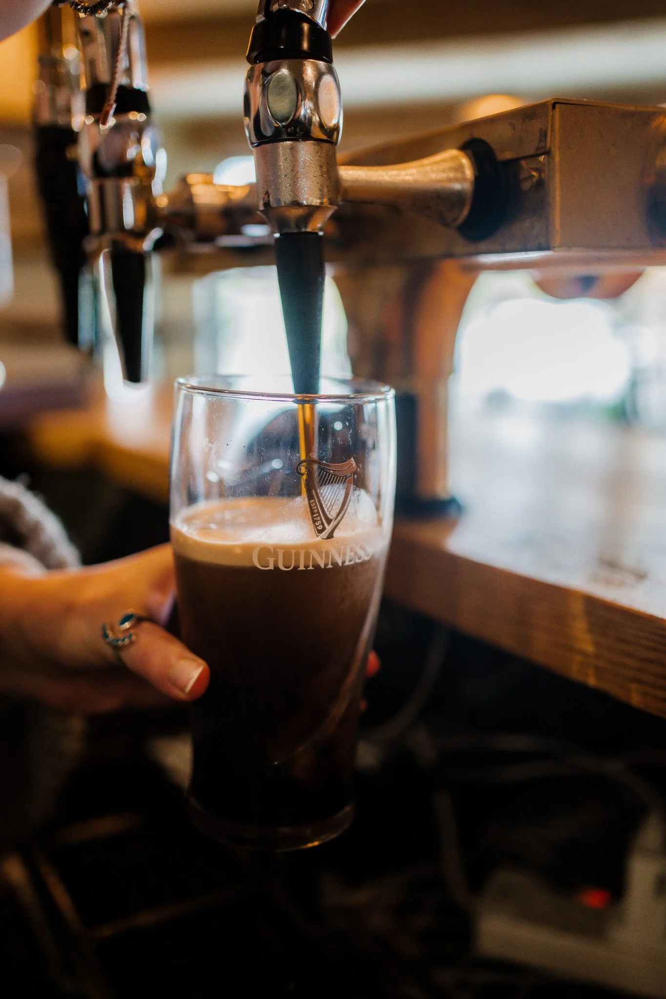 Guinness stout being poured from tap at The Thatched Inn pub bar in West Sussex.