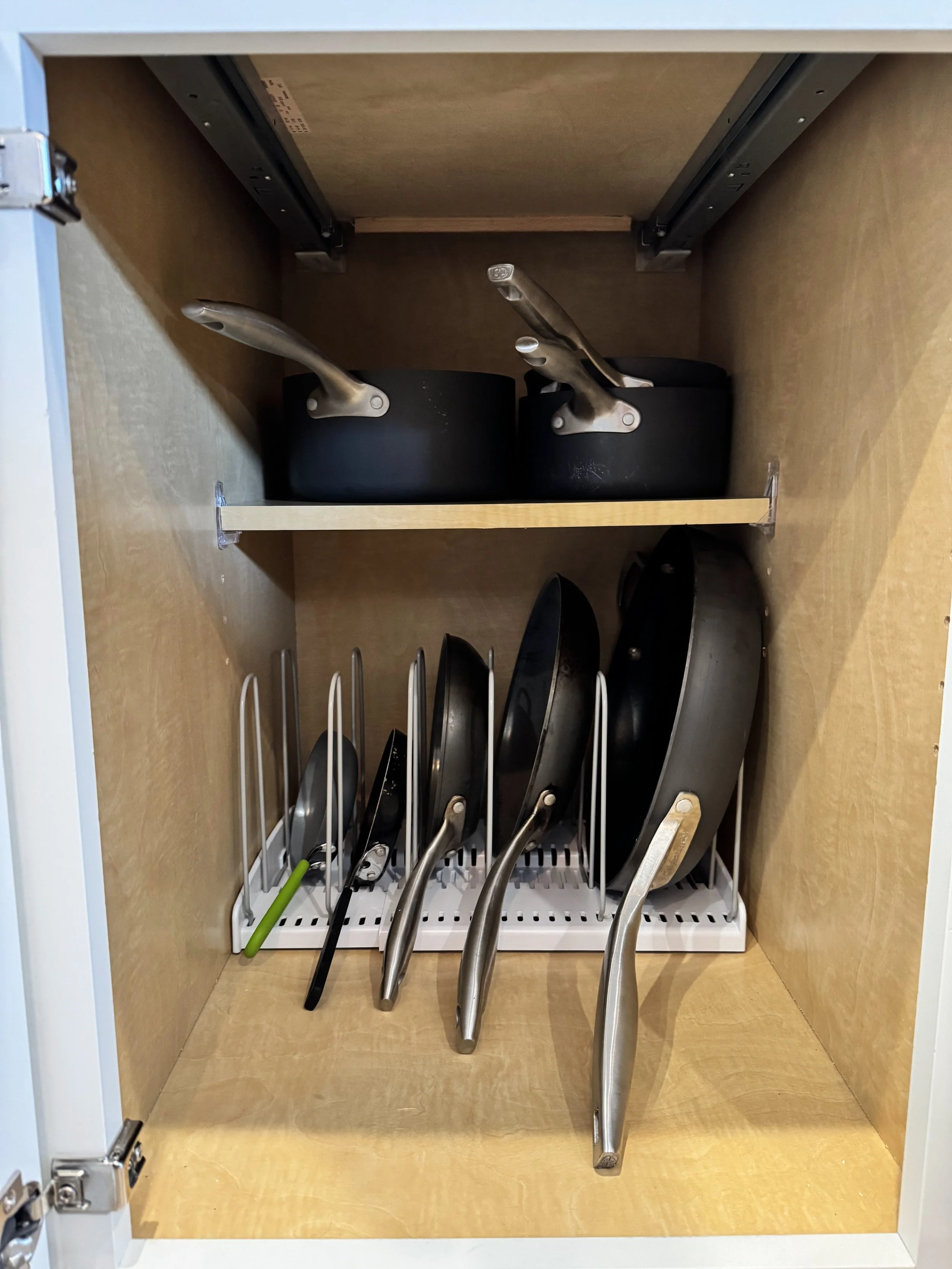 Organized pots and pans in a kitchen cabinet
