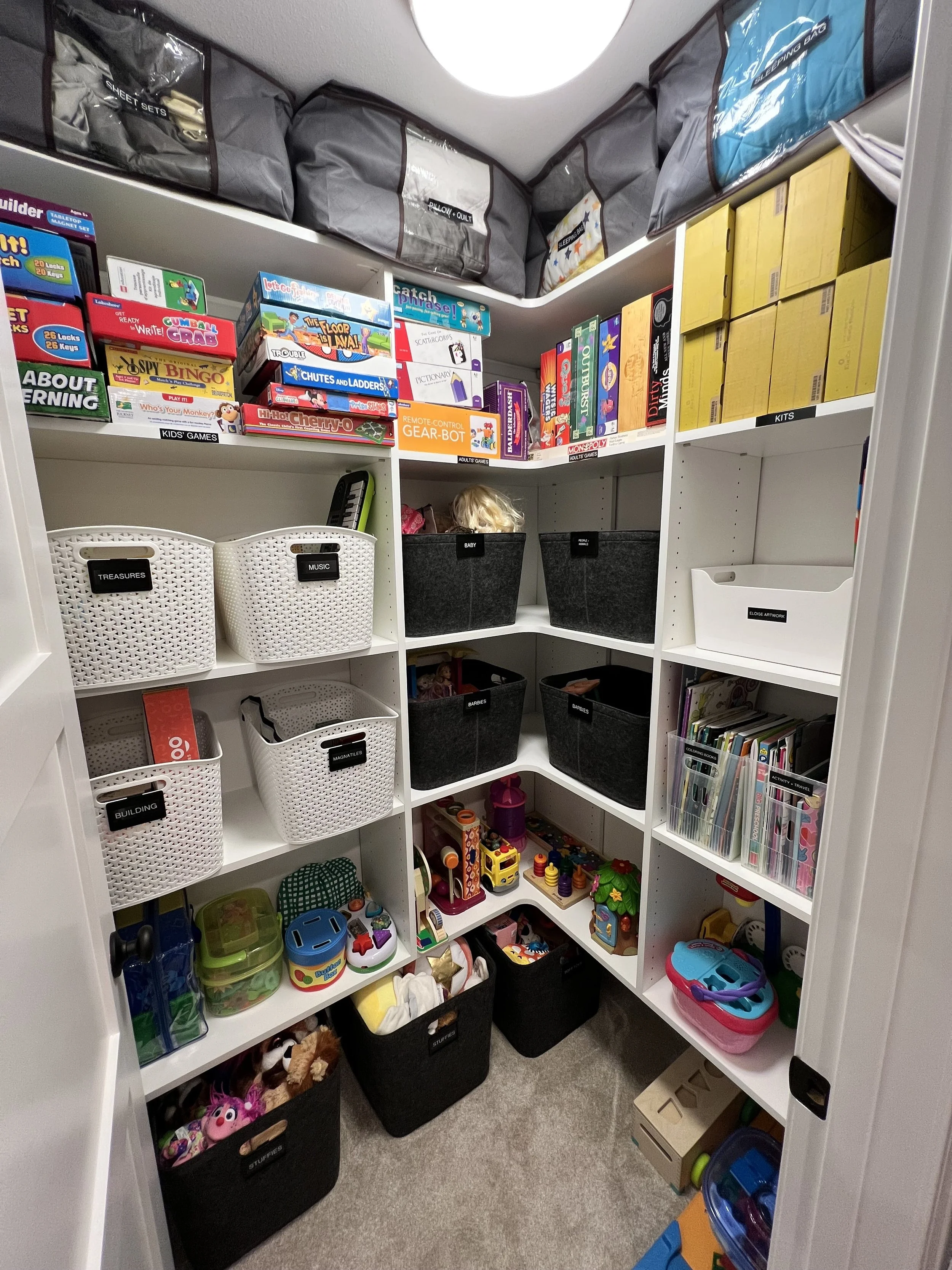 Playroom closet with white and black baskets and labels