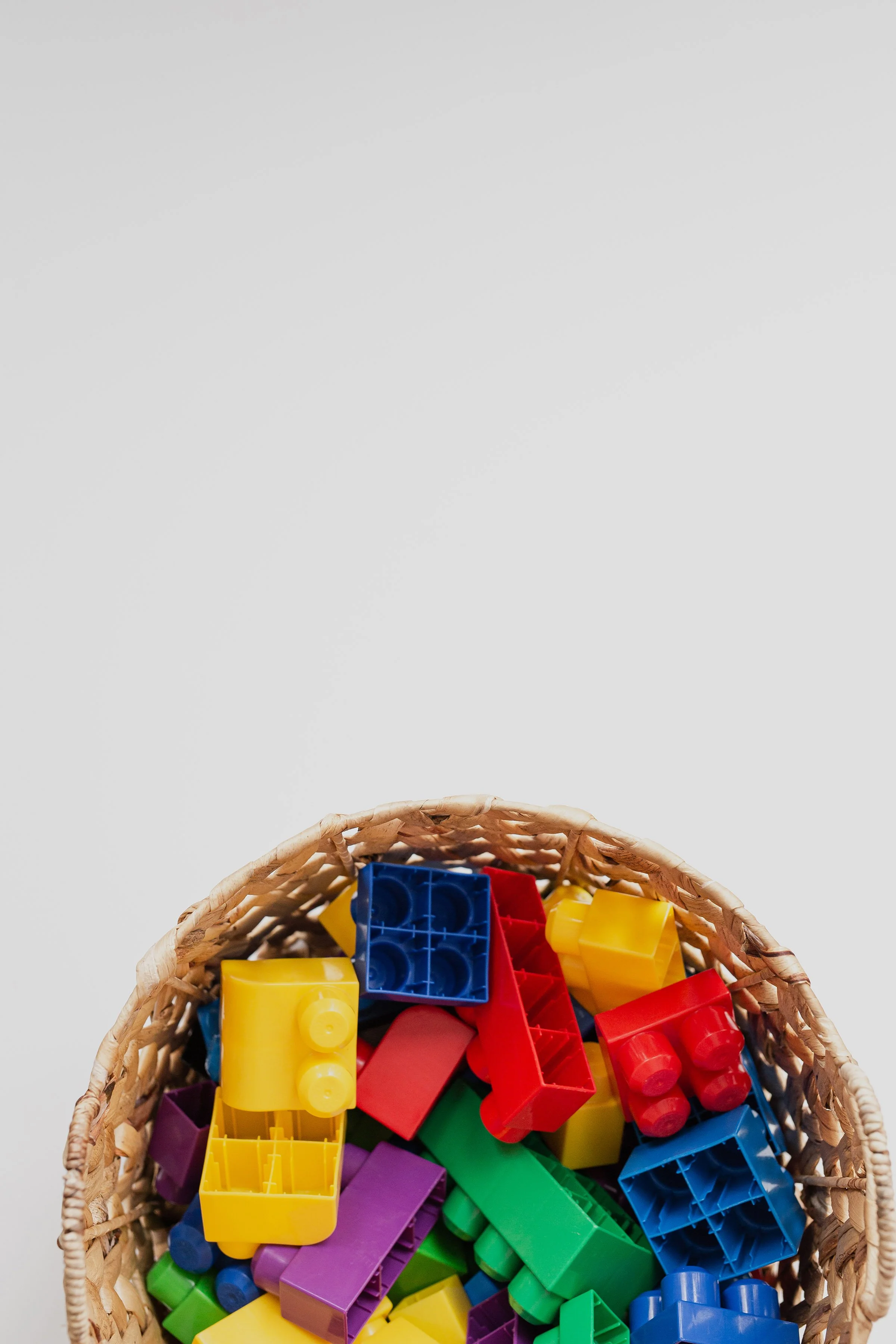 rainbow colored legos in a brown basket
