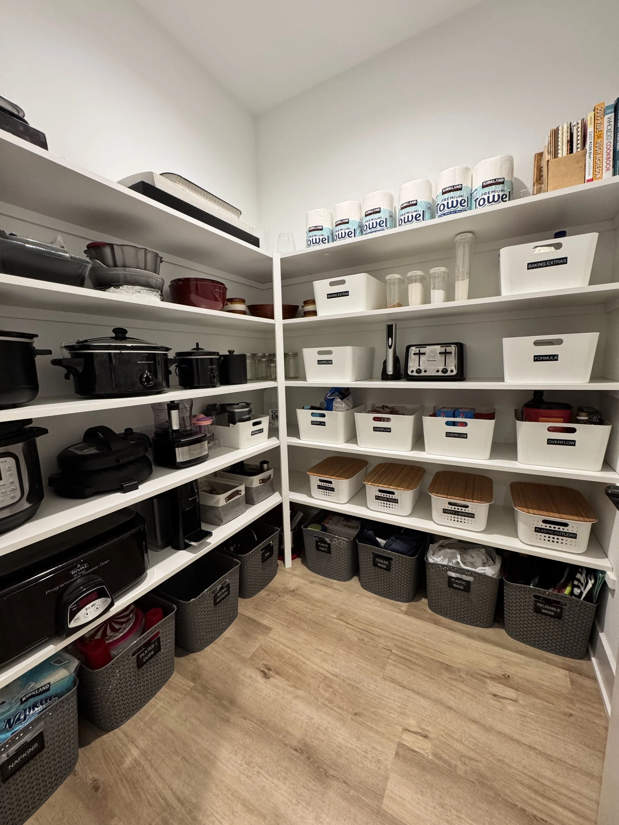 A walk-in pantry with gray and white containers and labels