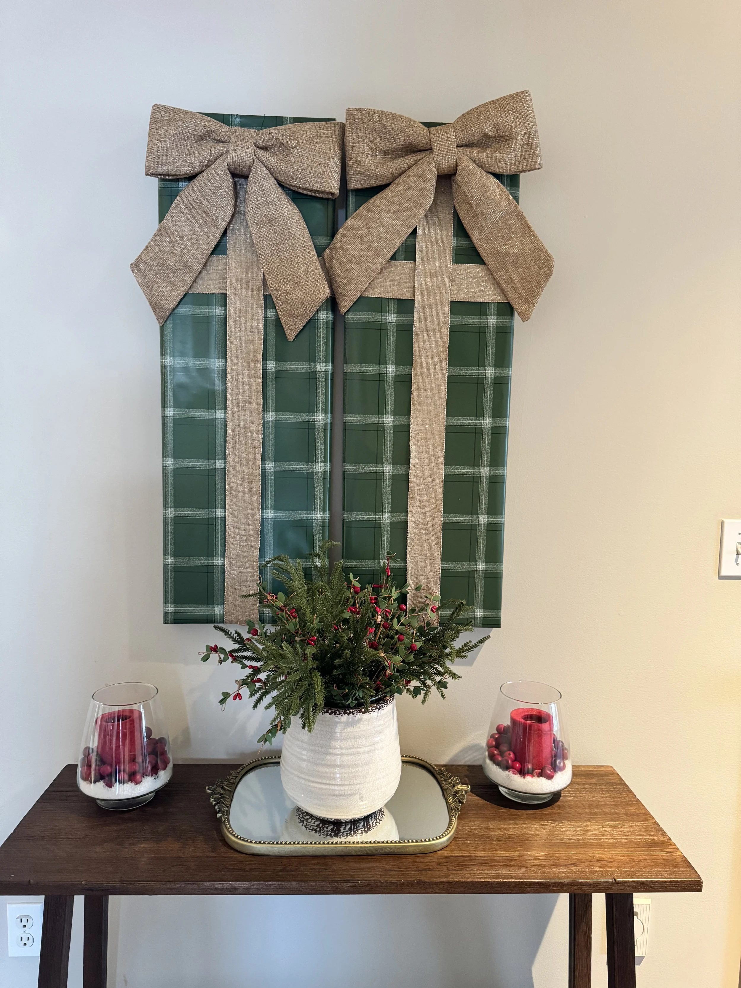 Green plaid wrapping paper with gold bows on two wall canvases