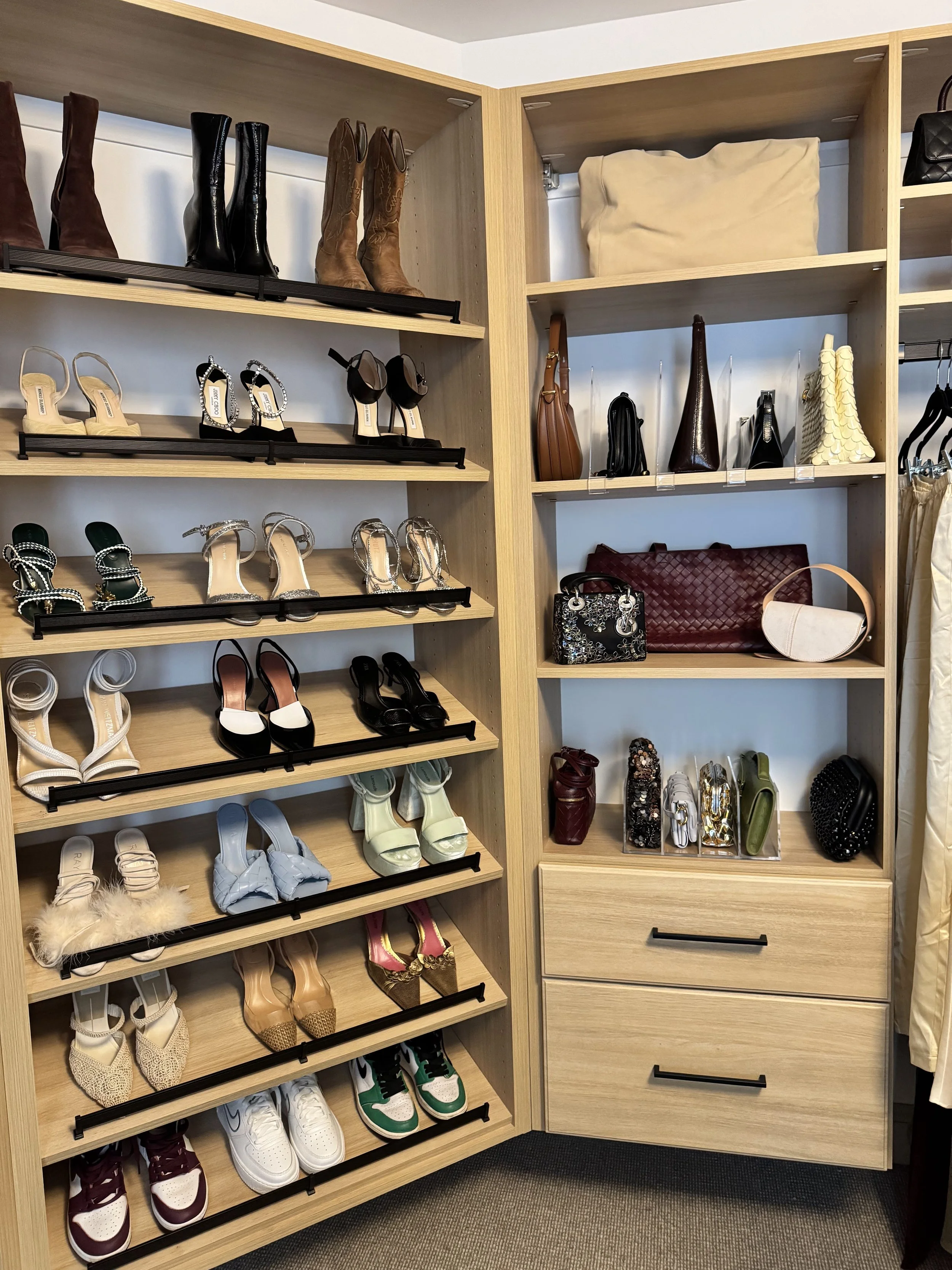 shoes and handbags arranged in an organized way in a primary closet