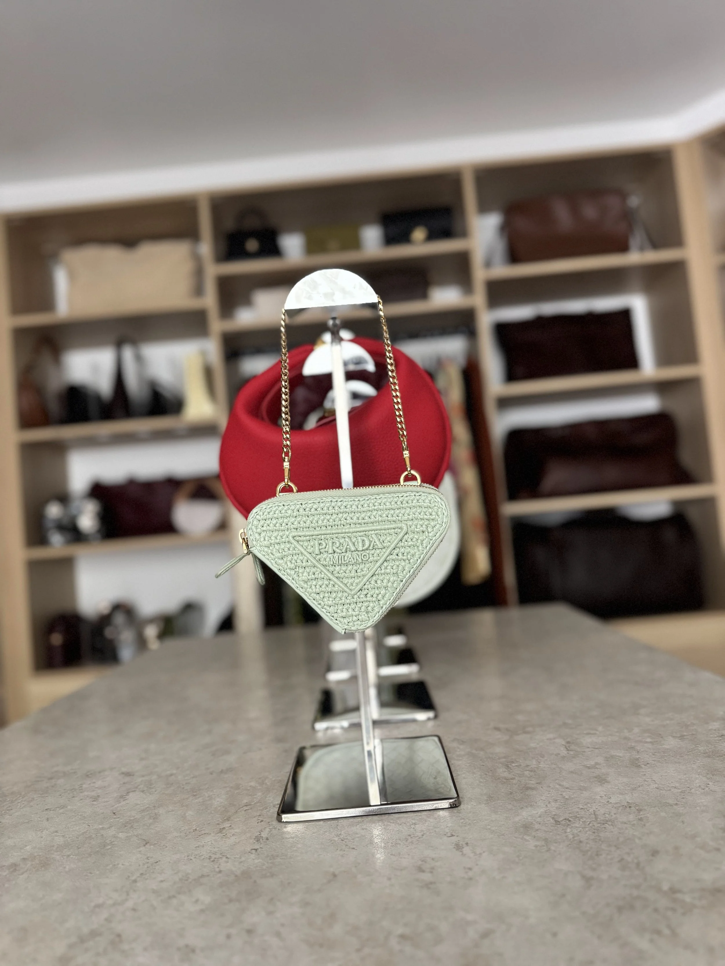 Luxury handbags in a closet with an island and light wood shelving