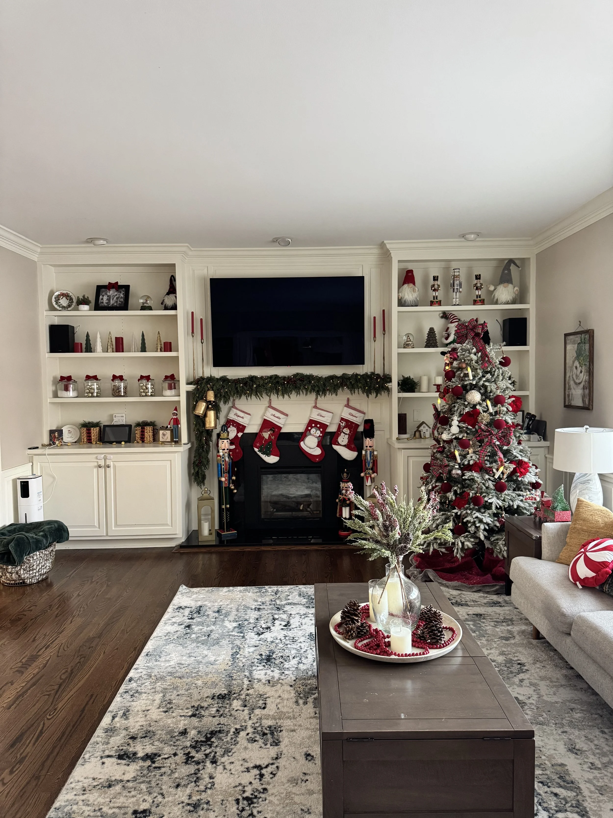 A family room decorated with a Christmas Tree and open bookshelves