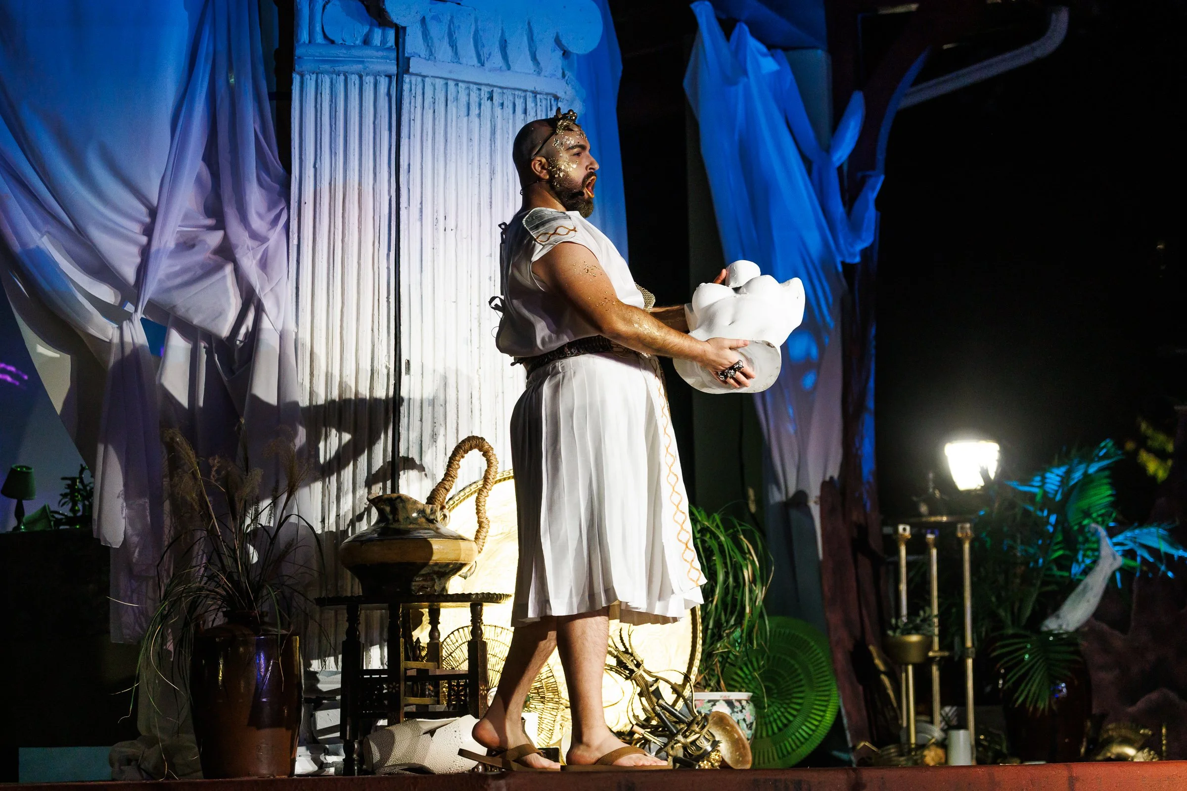 Person in sci-fi costume with face paint and prop weapon, shouting.