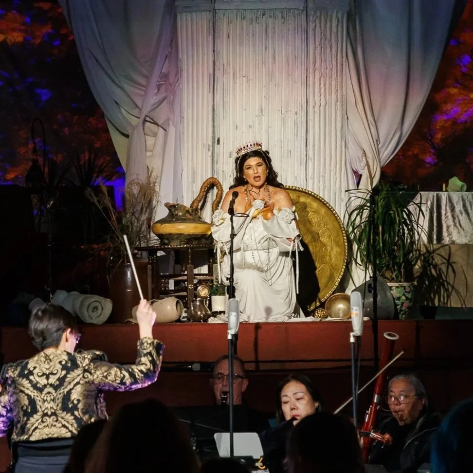 Person in colorful costume on stage with sci-fi backdrop