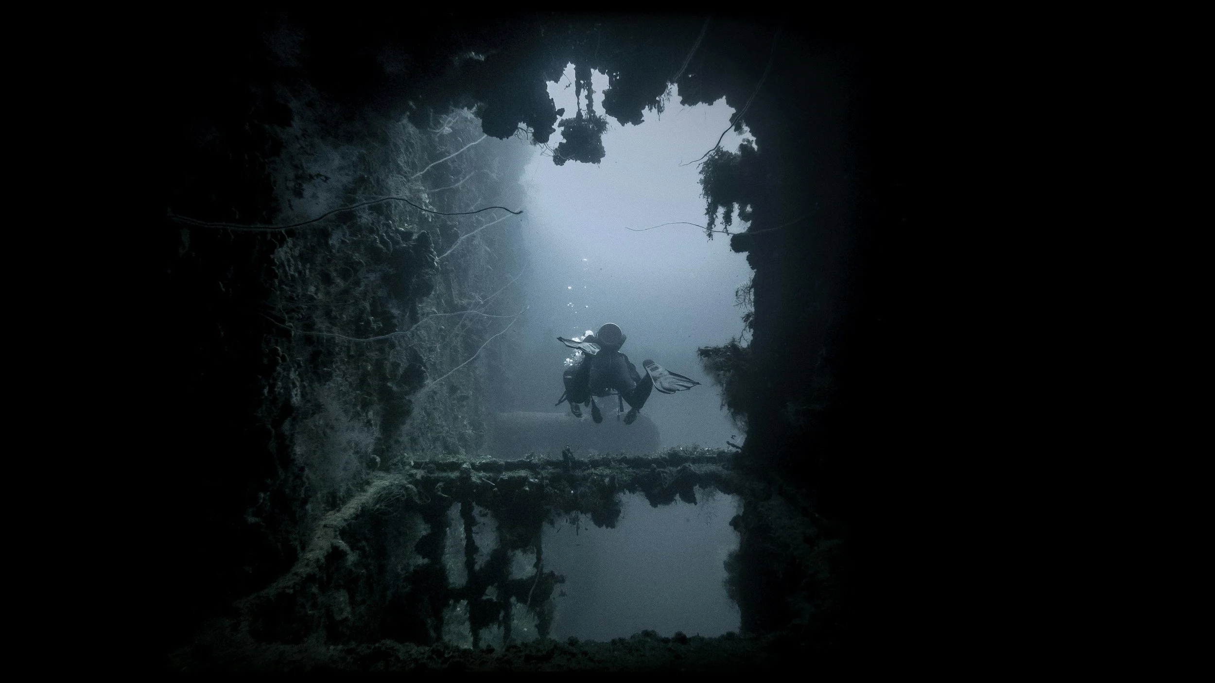 A scuba diver exploring an underwater shipwreck.