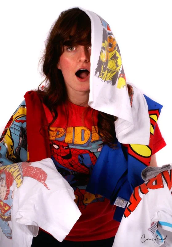 Woman dressed in Marvel superhero-themed clothing with towels draped over her head and shoulders, expressing a surprised or shocked reaction.