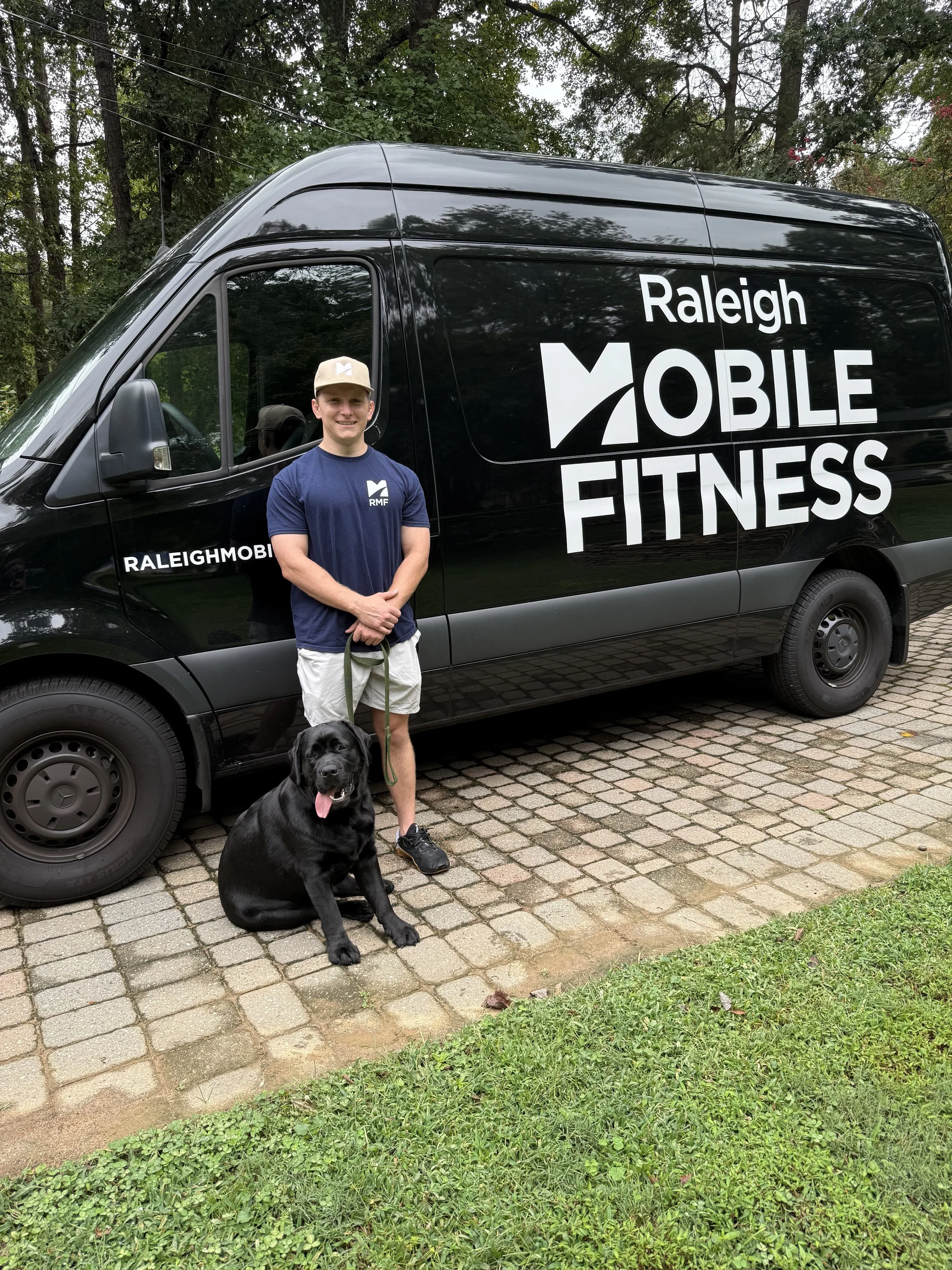 James, CSCS, with his lab standing in front of the Raleigh Mobile Fitness truck.