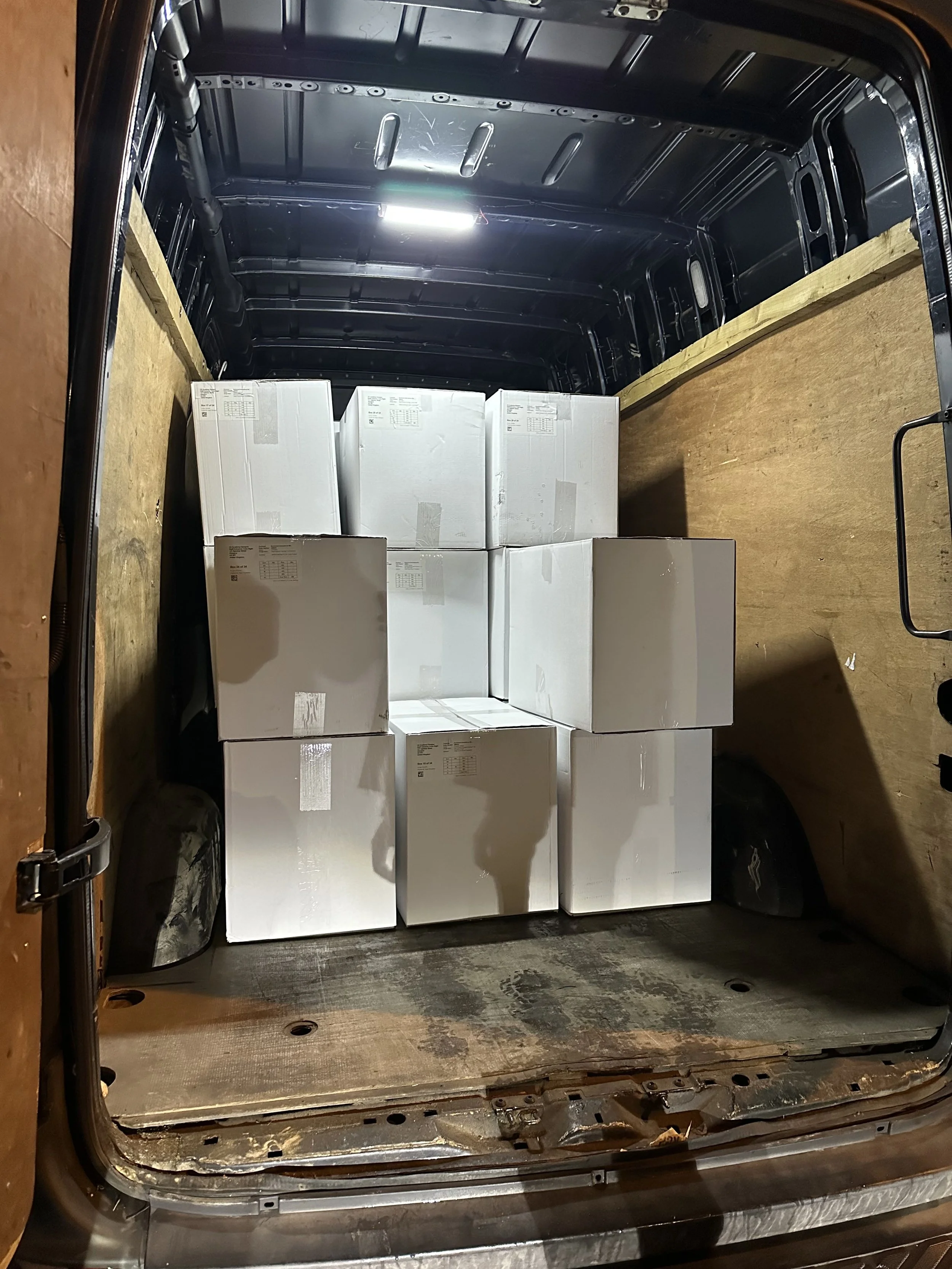 Stacked tour merch in back of a van.