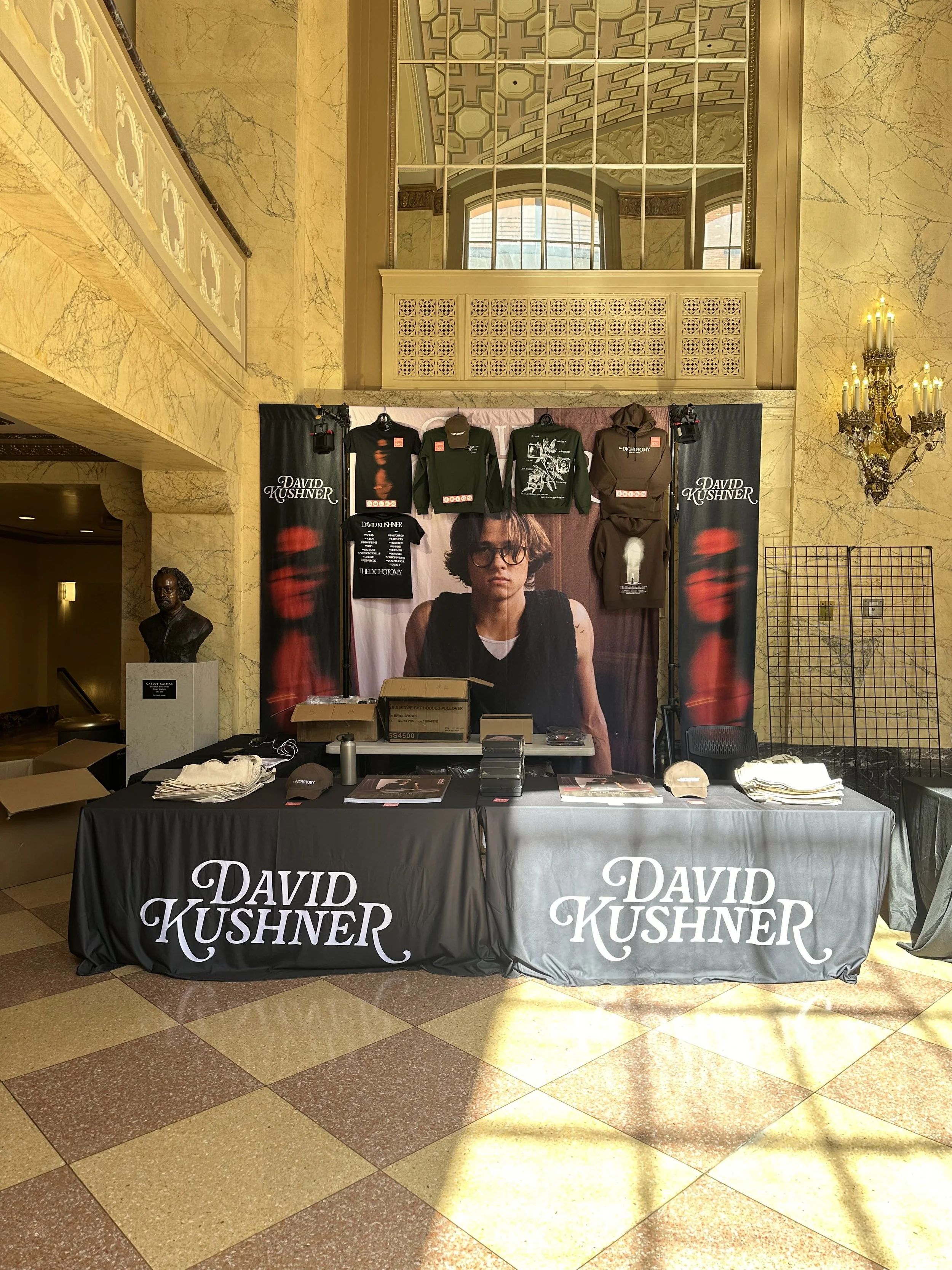 Touring merch booth setup in large lobby.