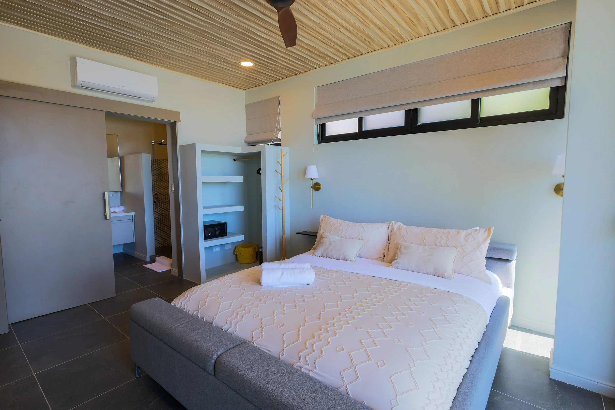 Master bedroom featuring a king-size bed, private balcony, and ensuite bathroom.