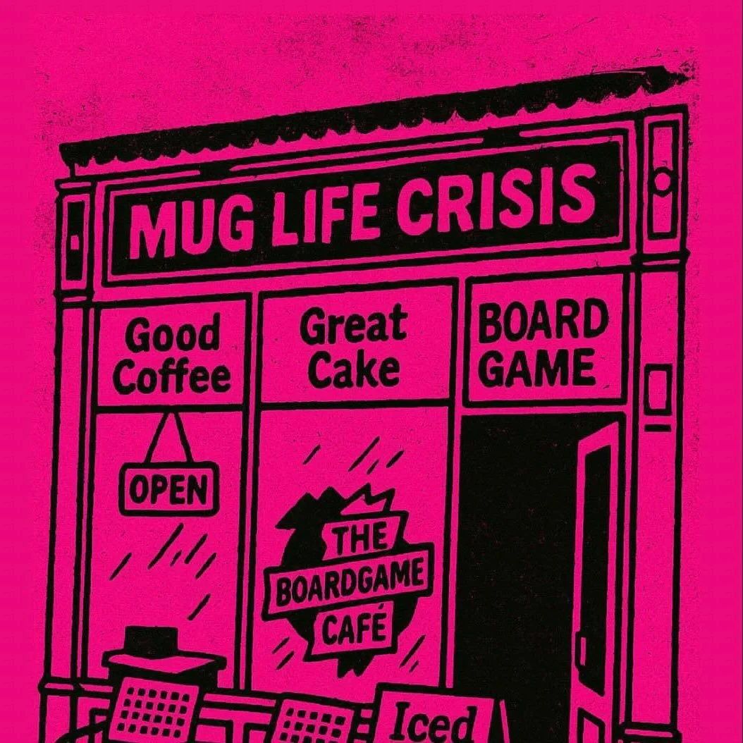 A pink storefront sign titled "Mug Life Crisis" with sections for "Good Coffee," "Great Cake," and "Board Game." A door with a small sign reading "Open" and a logo for "The Boardgame Cafe."