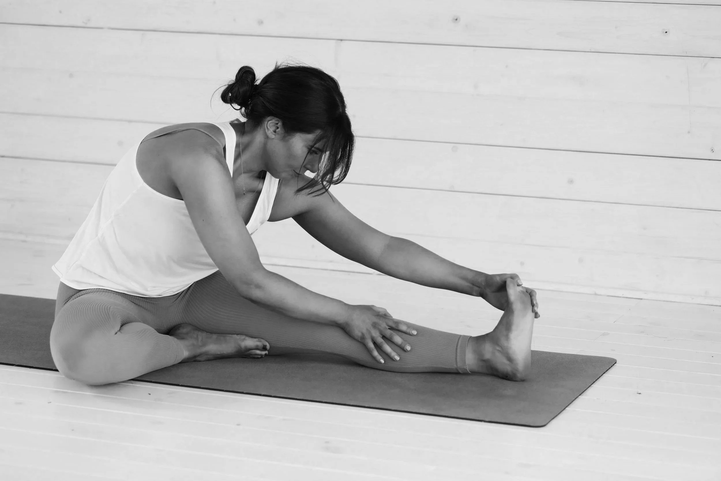 Frau dehnt sich auf Yogamatte – Vinyasa Yoga Kurs in Niedernhausen