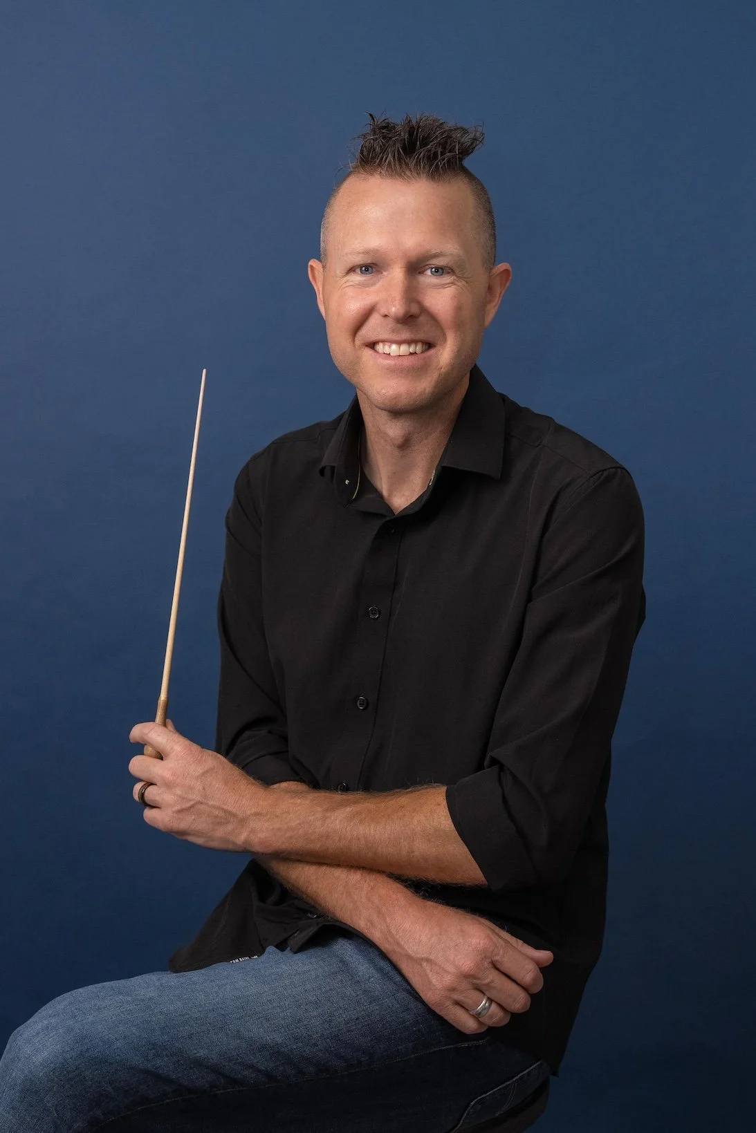 Maestro Jeffery Dokken holding a conductor's baton.