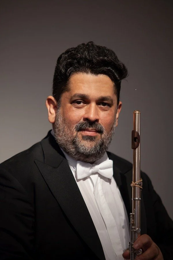 Headshot of James Strauss posing with his flute.