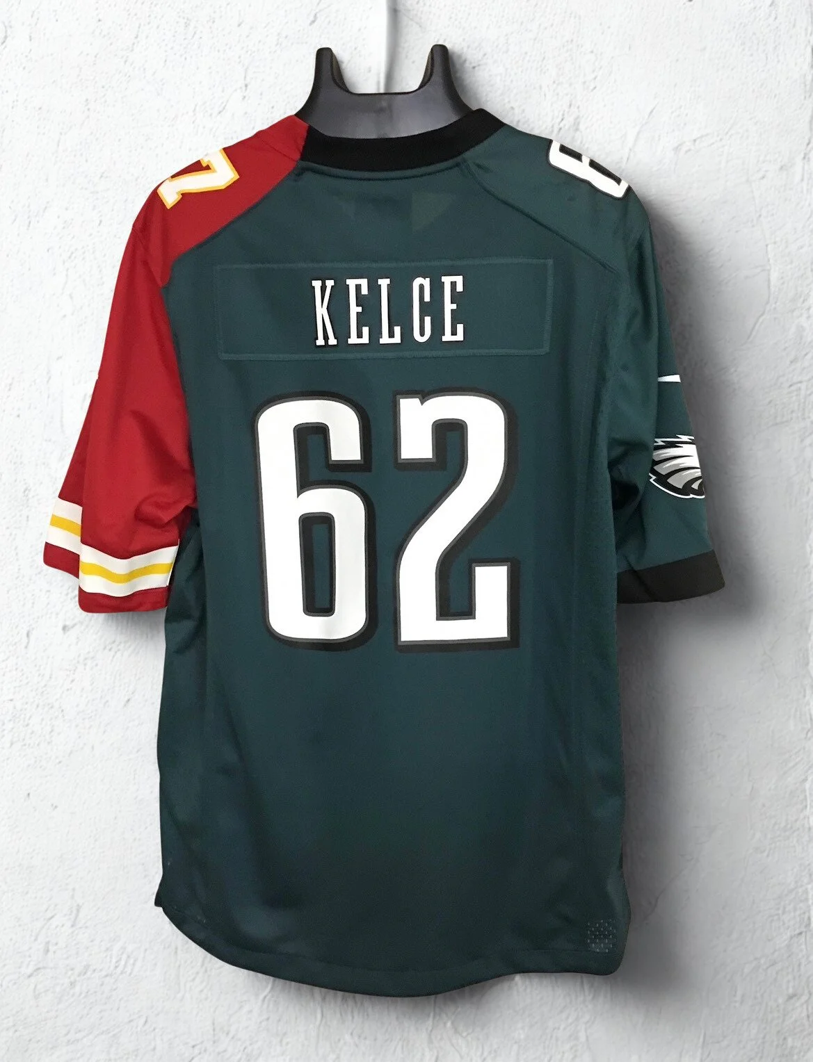 Philadelphia Eagles and Kansas City Chiefs Split  jersey with green body, red and black sleeves, and the name 'KELCE' with the number '62' displayed on the back.