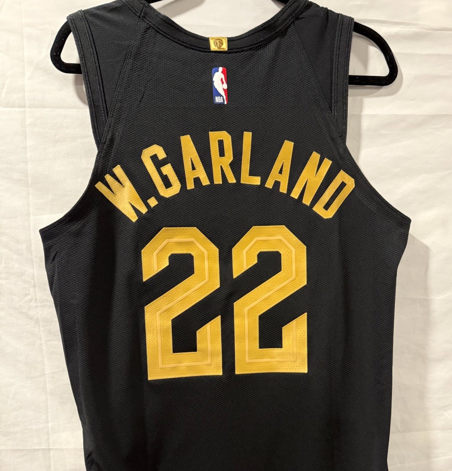 Black basketball jersey with gold lettering and number. The name 'W. GARLAND' and the number '22'. NBA logo on the back.