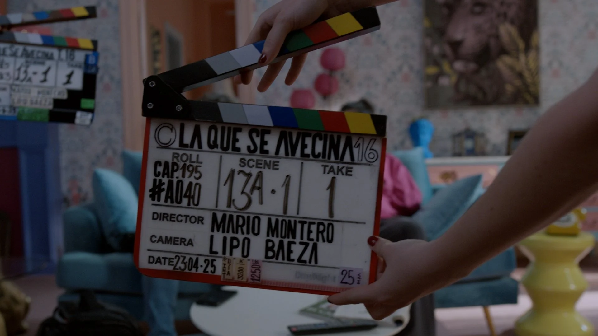 Film clapperboard with scene and take information in a living room set.