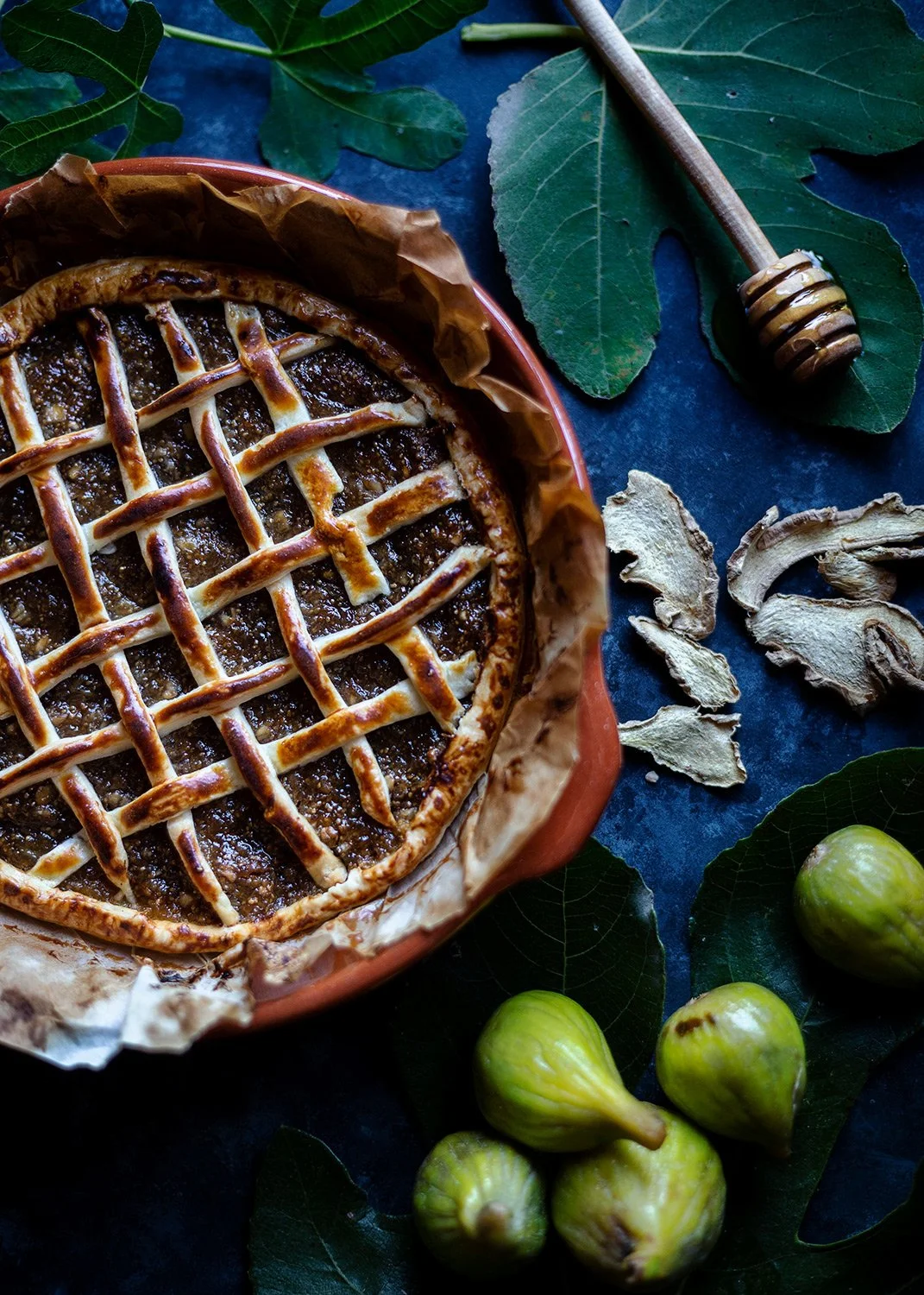 Moody food photography of a fig pie with honey and ginger
