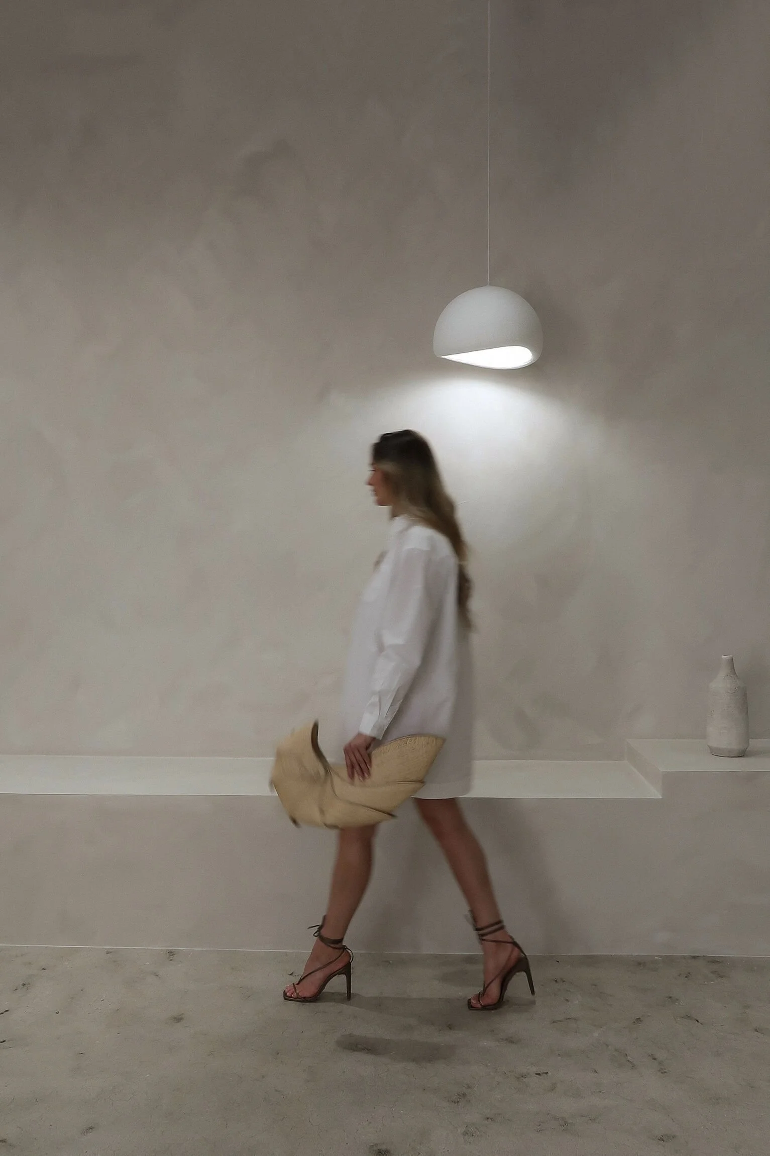 Woman in chic outfit Woman in chic outfit walking through minimal, modern interior—reflecting the sophisticated style of Valos Hair Salon