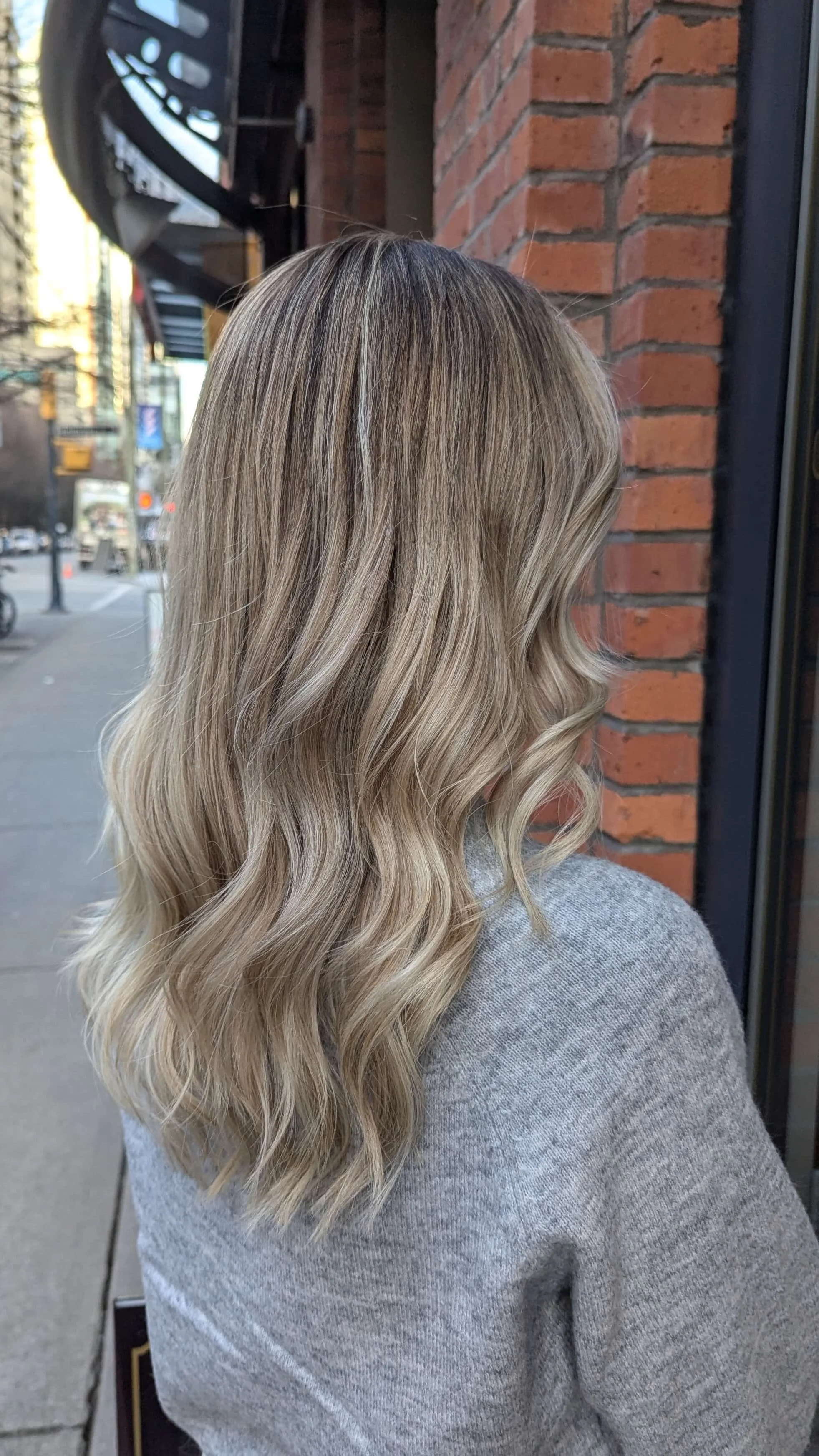 Luxury layered warm-blonde color and blowout, styled by Valos Hair Salon in Vancouver