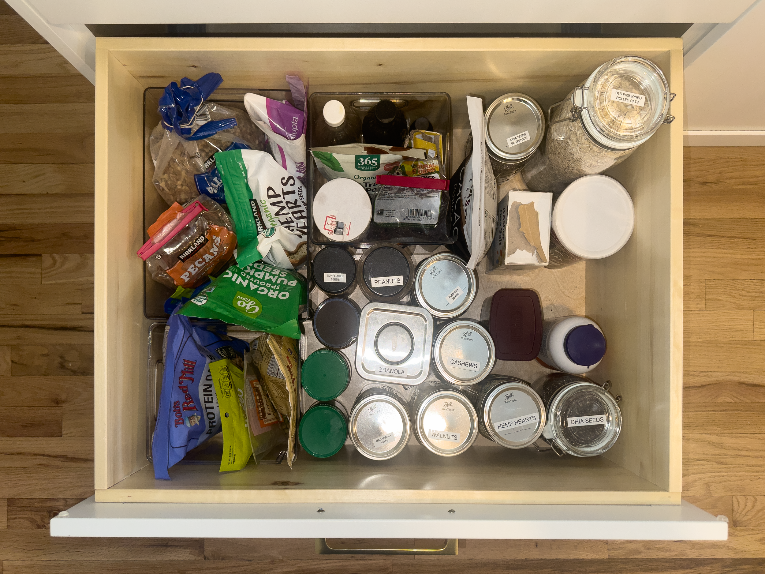 After image of a pantry drawer that has been professionally organized by Strategic Spaces in Denver, CO and includes labeled jars and clear backstock.