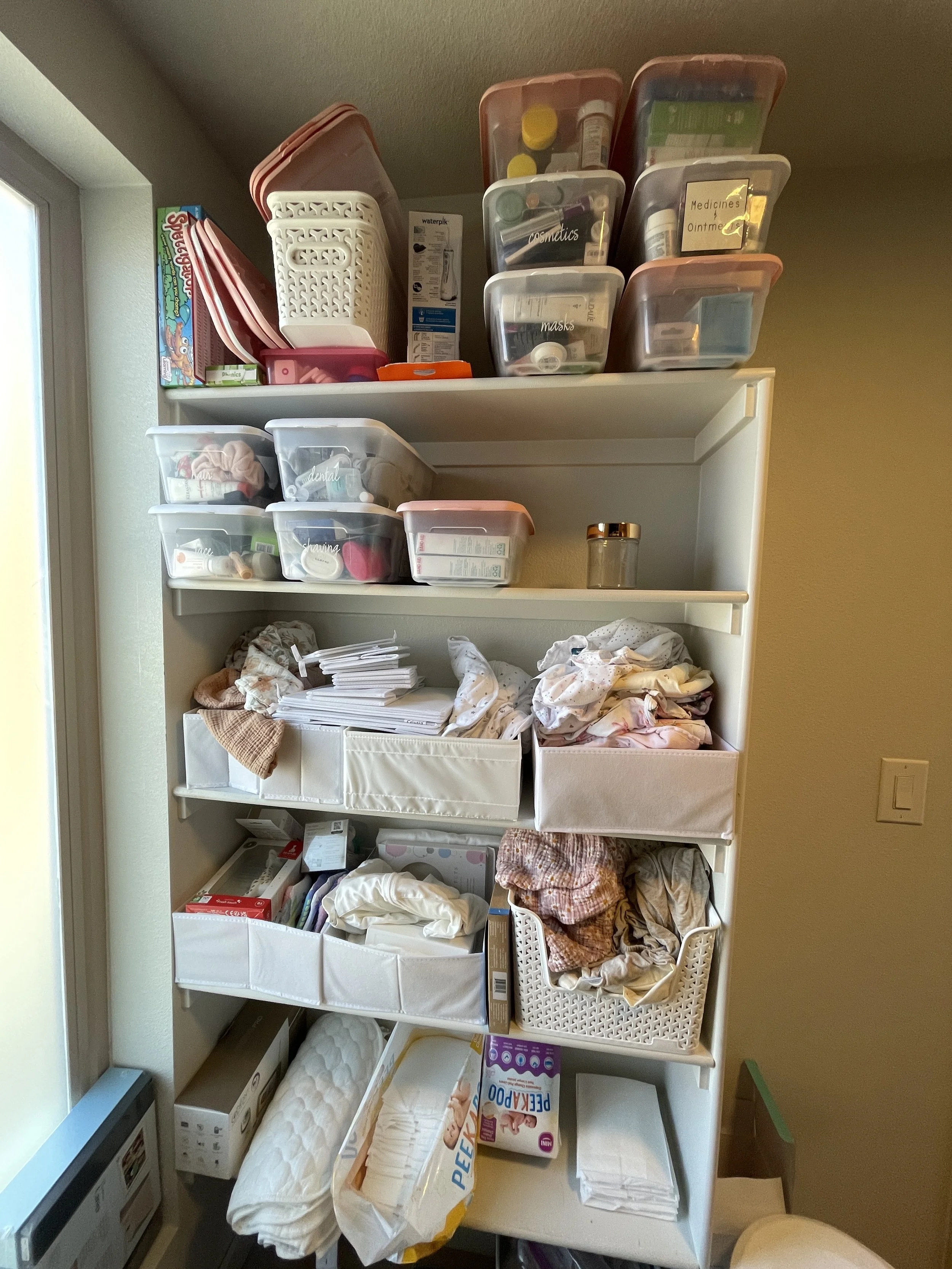 Before image of a disorganized bookshelf of baby supplies