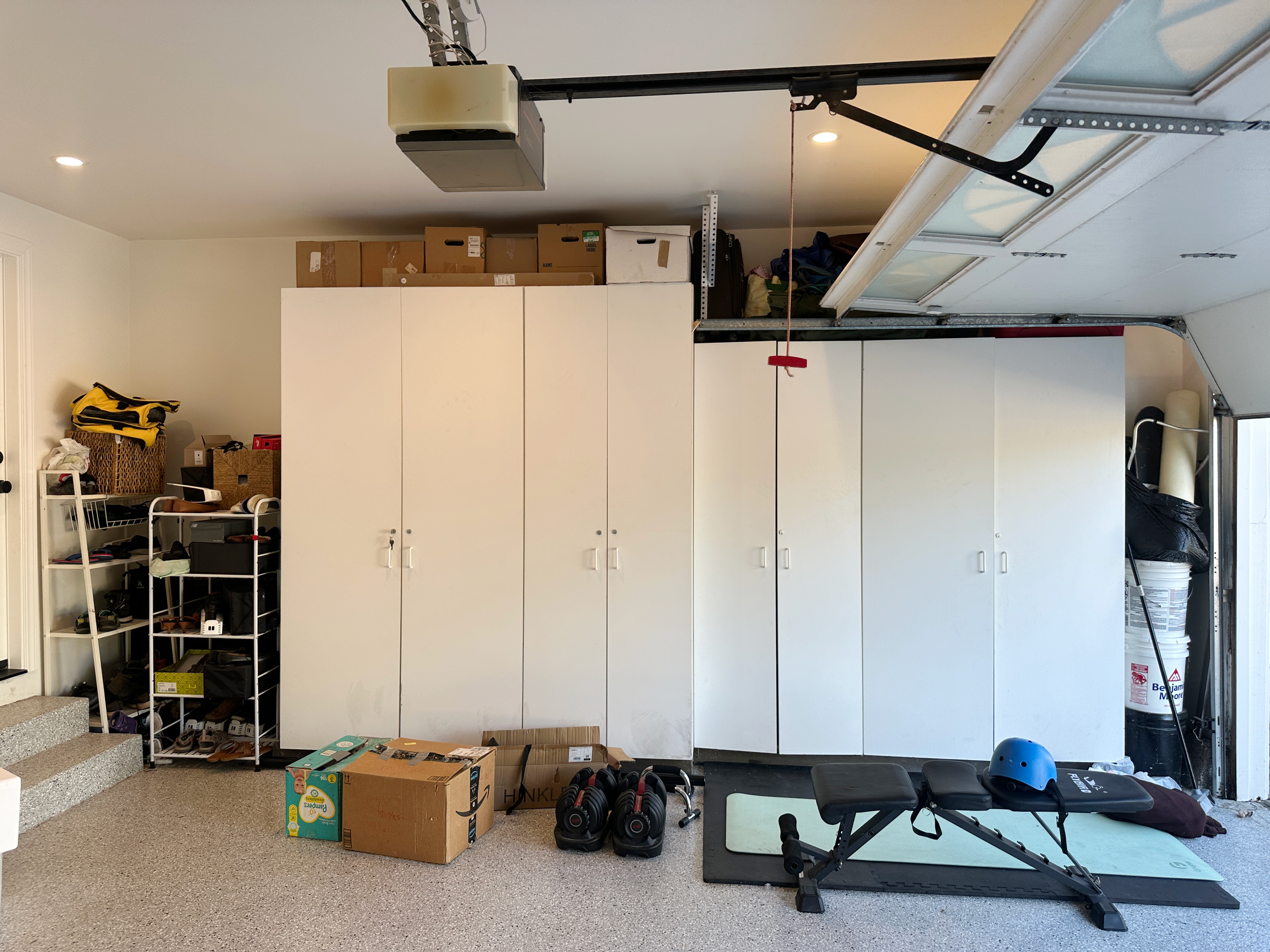 Before image of a garage storage system with a disorganized shoe system on the left.