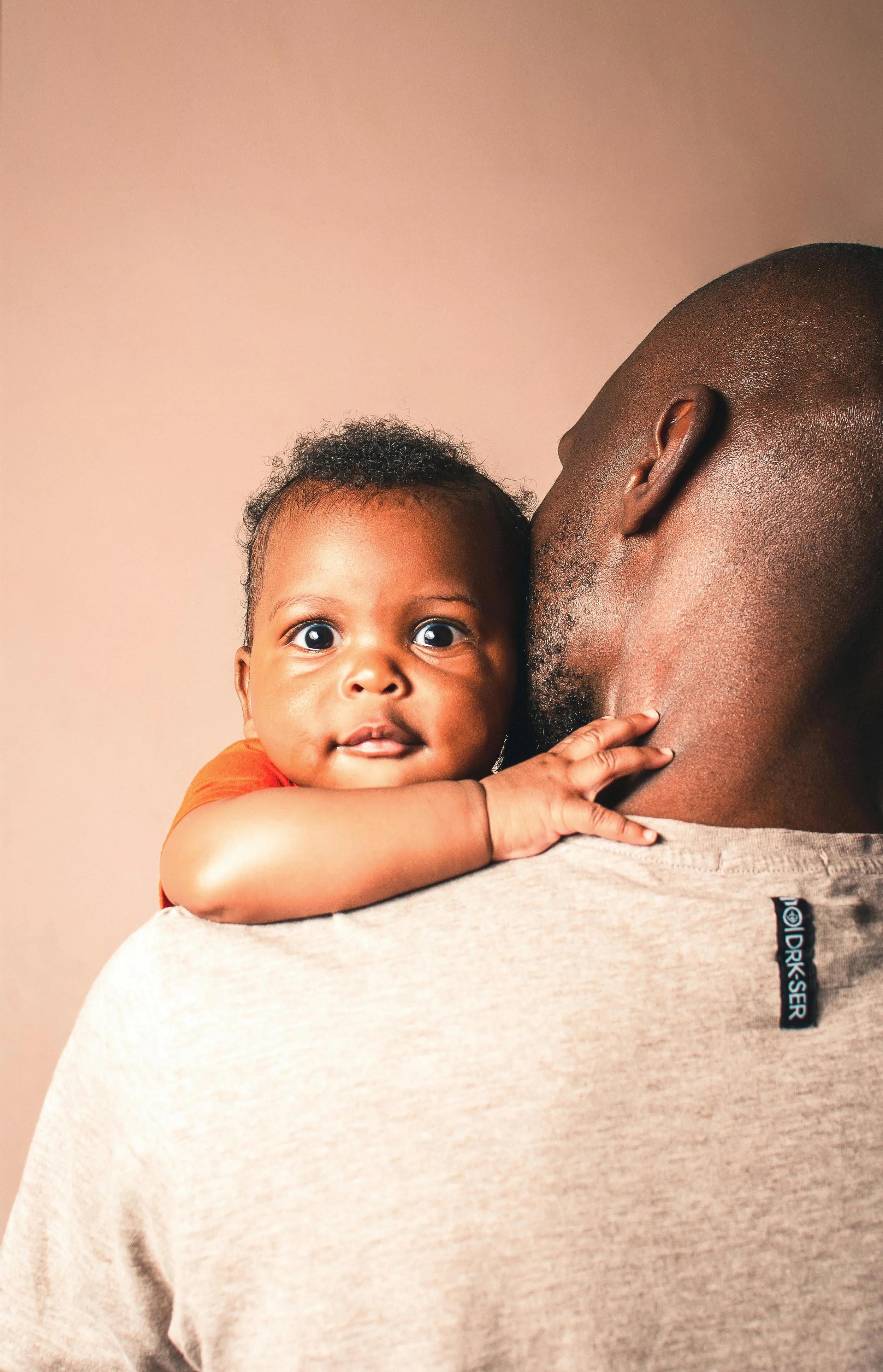 baby cuddles over shoulder