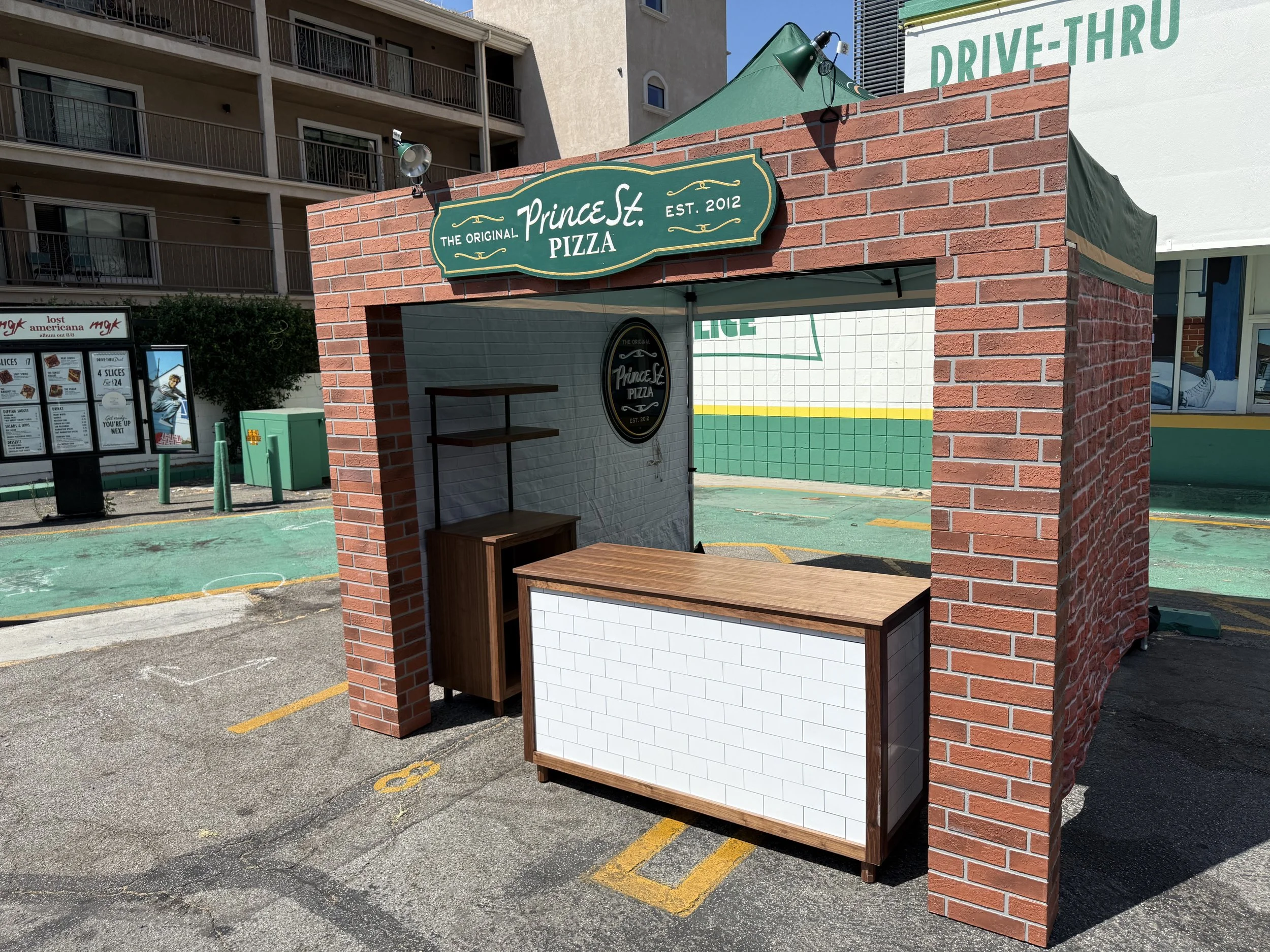 Prince Street Pizza custom p for events, food festivals, music festivals and special occasion service. Walnut countertop service table with white subway tiles and an exposed brick arch facade