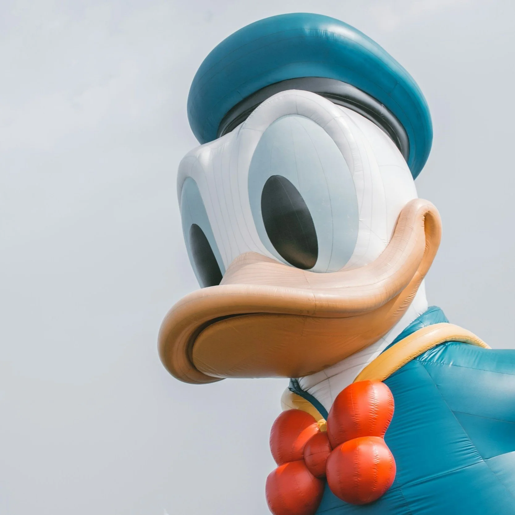 Large inflatable cartoon duck with sailor hat and bow tie.