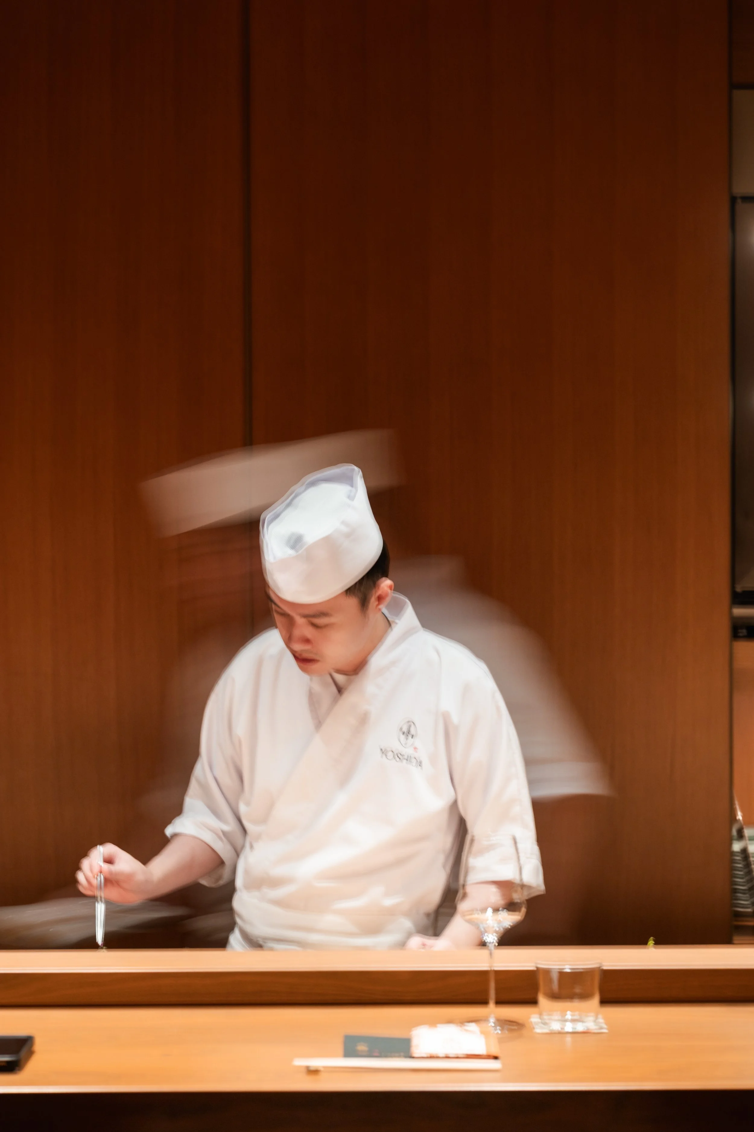A sushi chef at work behind the counter, focused and unhurried.