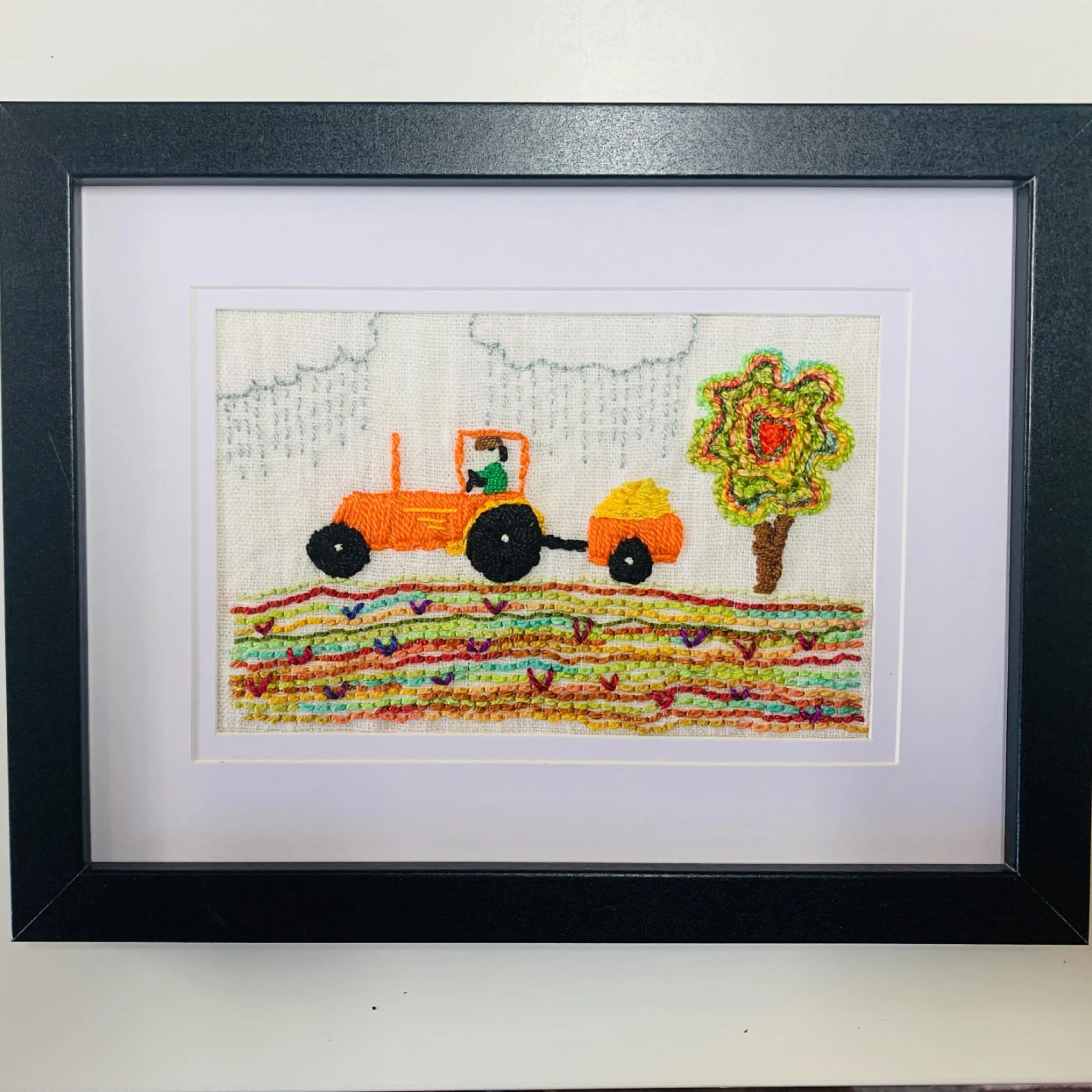 Work never stops even in the rain! Embroidery with a bit of fun. #handstitched #textileartist #embroideryart #tractors #colourful